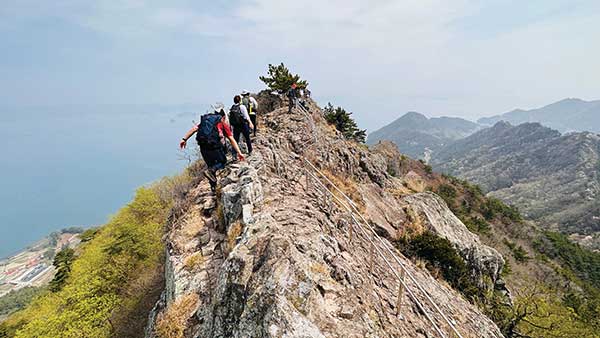 등산객들이 사량도 지리산의 가장 위험한 칼바위 능선 구간을 조심스럽게 오르고 있다.