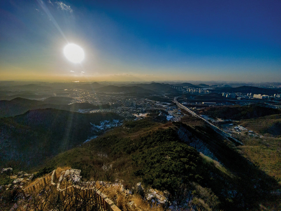 수암봉에서 바라본 일몰. 수도권 제1순환고속도로와 수인산업도로가 지나는 안산시가 한눈에 내려다보이고, 멀리 서해의 시화호가 붉게 물든다.