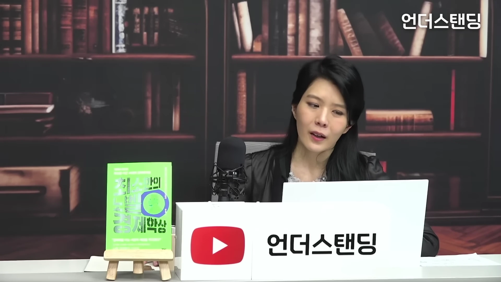 책상에 책을 두고 대담을 진행하는 김나영 작가의 인터뷰 장면