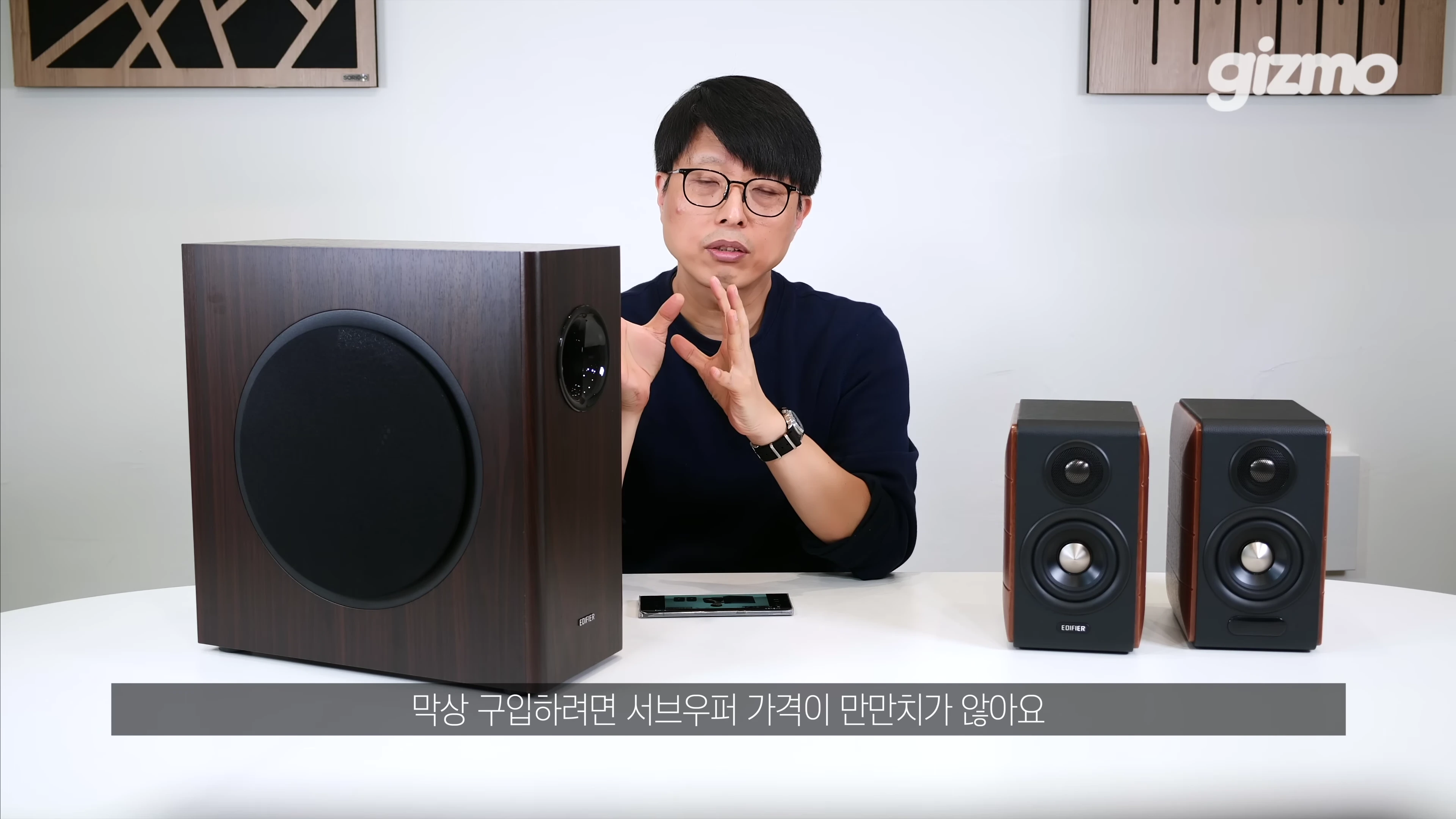 에디파이어 서브우퍼와 스피커를 앞에 두고 설명하는 남성의 토크 장면