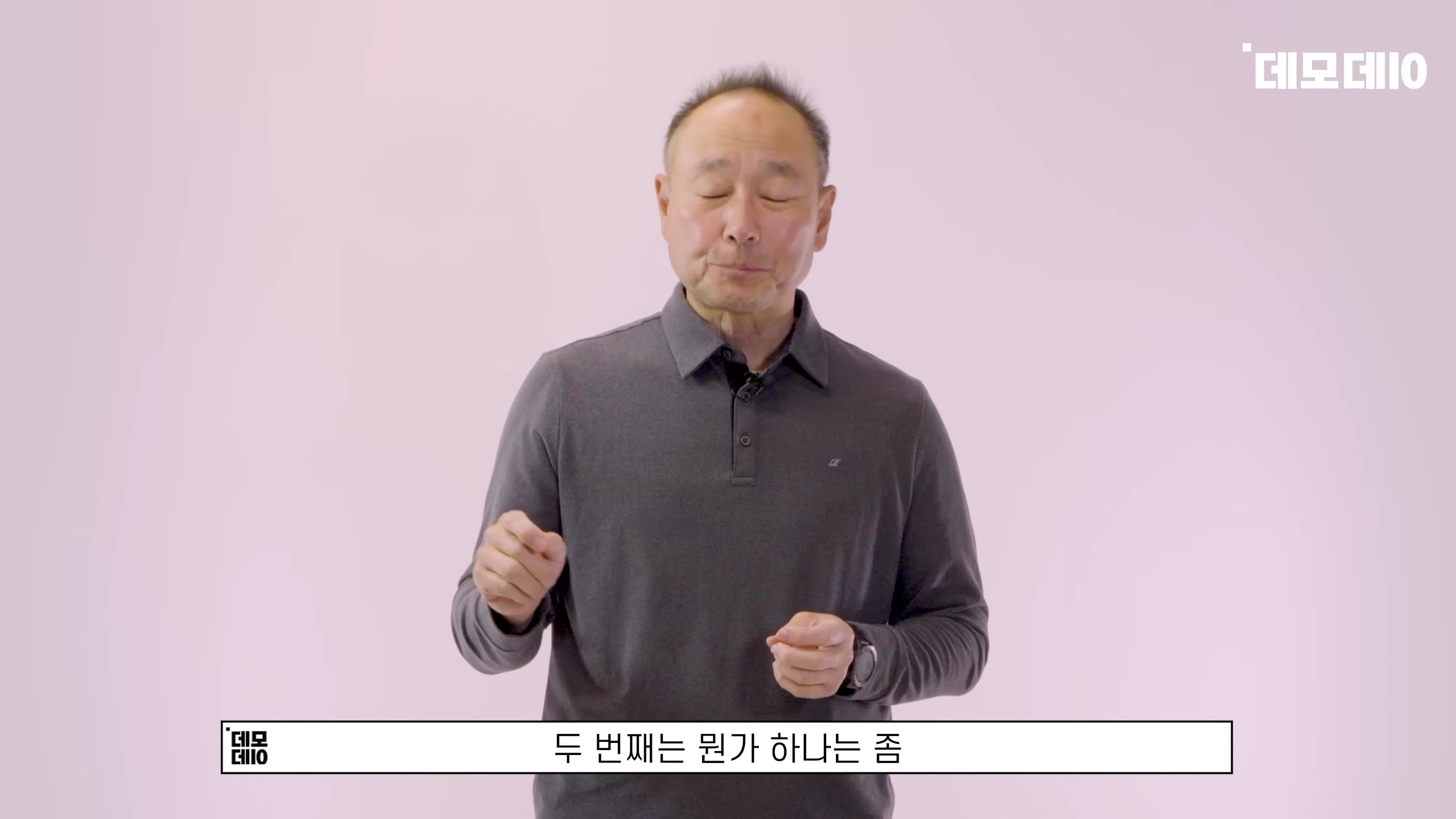 회색 폴로 셔츠를 입은 중년 남성이 진지하게 대화하는 토크 장면