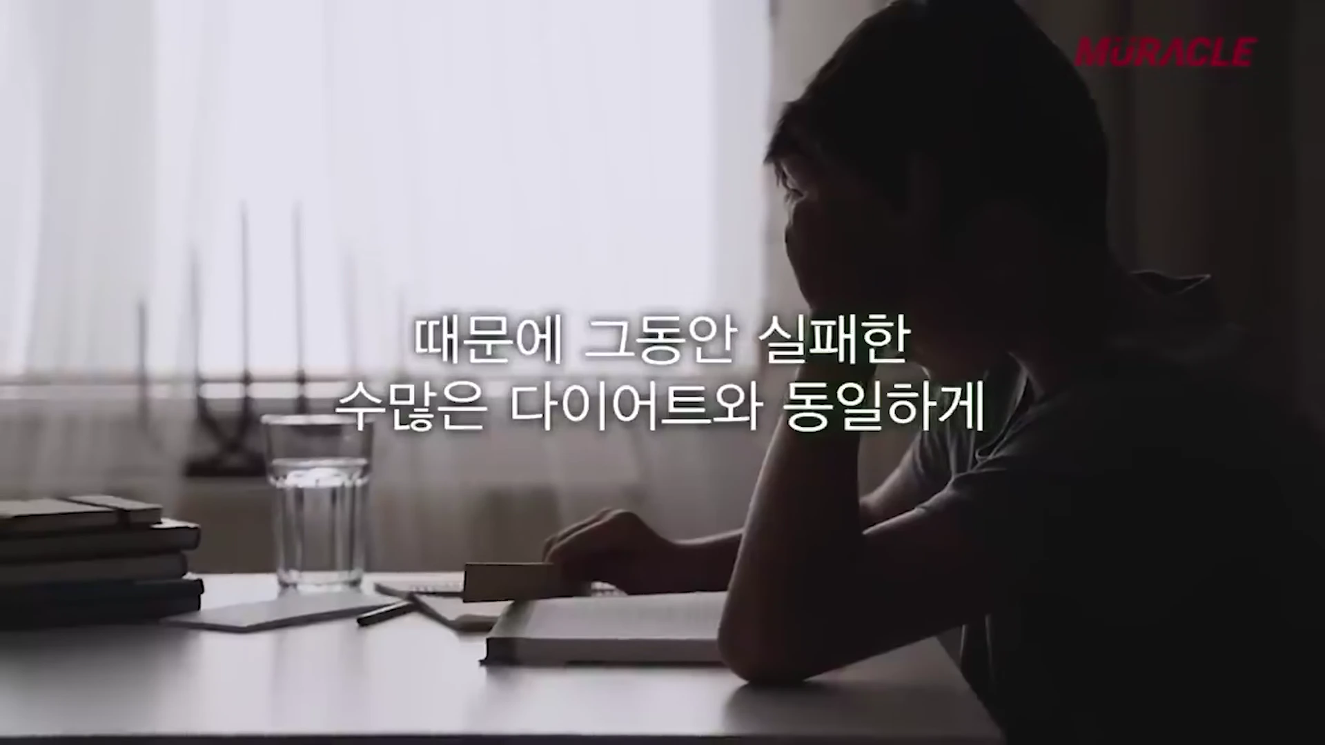 어두운 실내에서 책상에 앉아 고민하는 사람의 실루엣