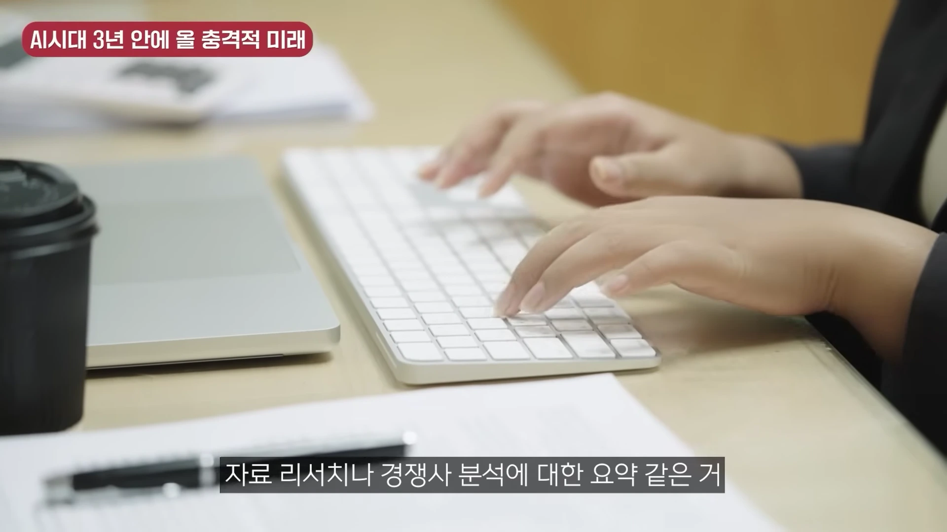 사무실 책상에서 키보드를 타이핑하는 사람의 손과 노트북