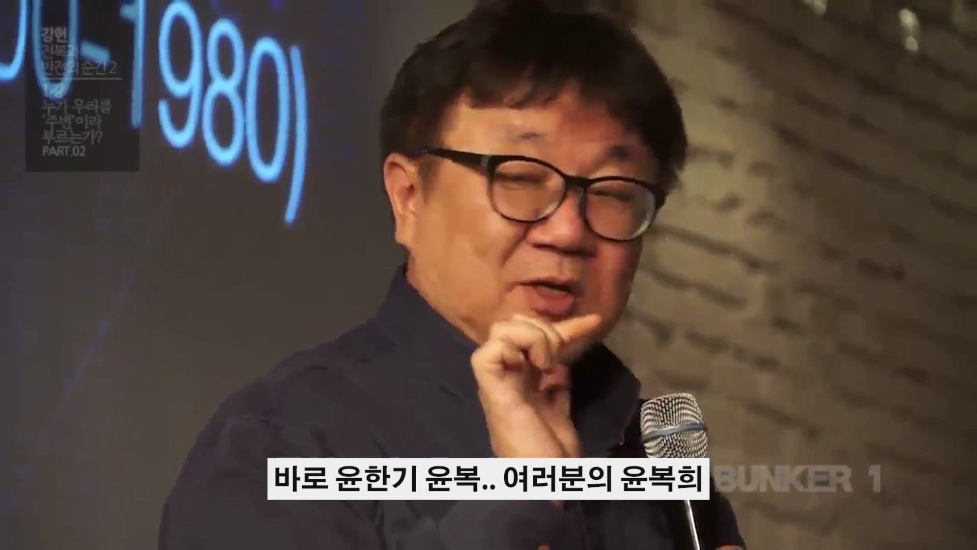 안경을 쓴 중년 남성이 마이크를 잡고 강연하는 모습이 담긴 영상 캡처 화면