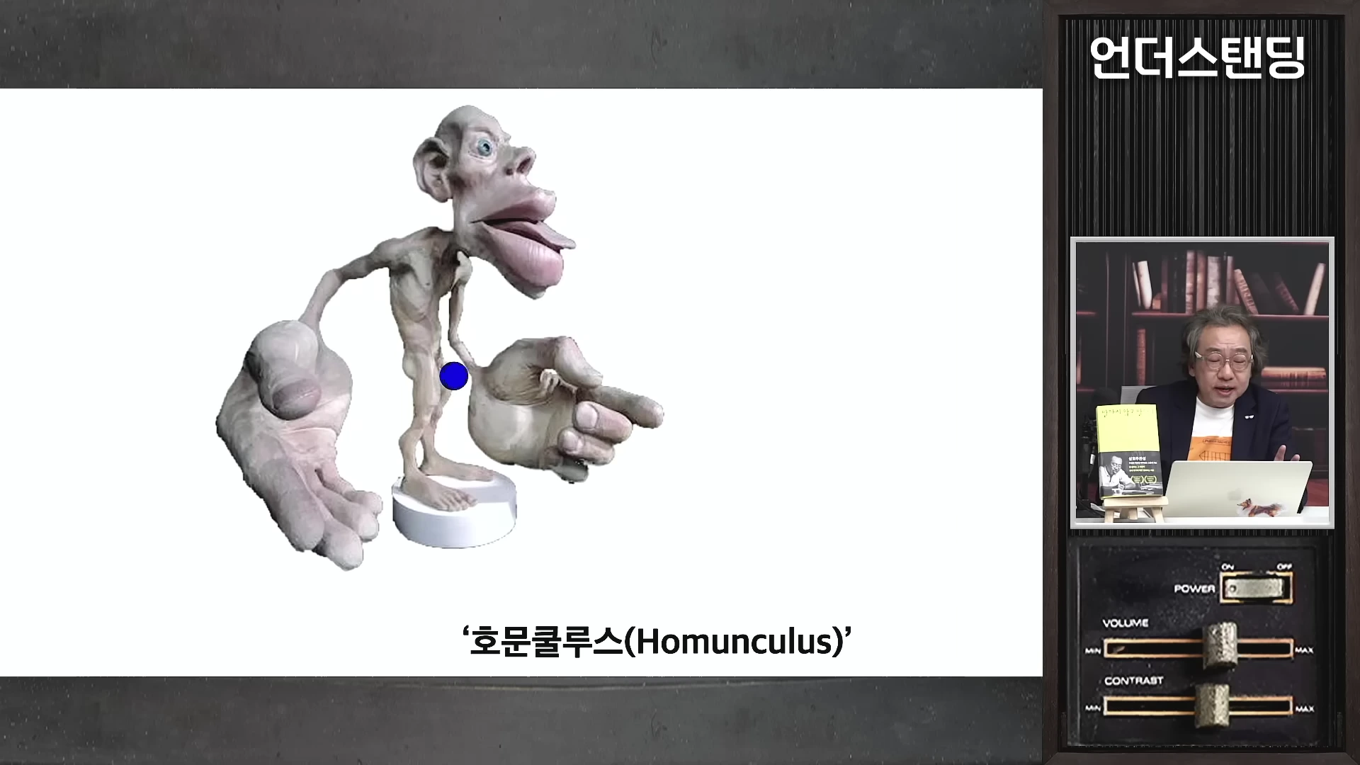 손과 입술이 비정상적으로 큰 기괴한 모습의 호문쿨루스 모형이 화면에 나타나 있다.