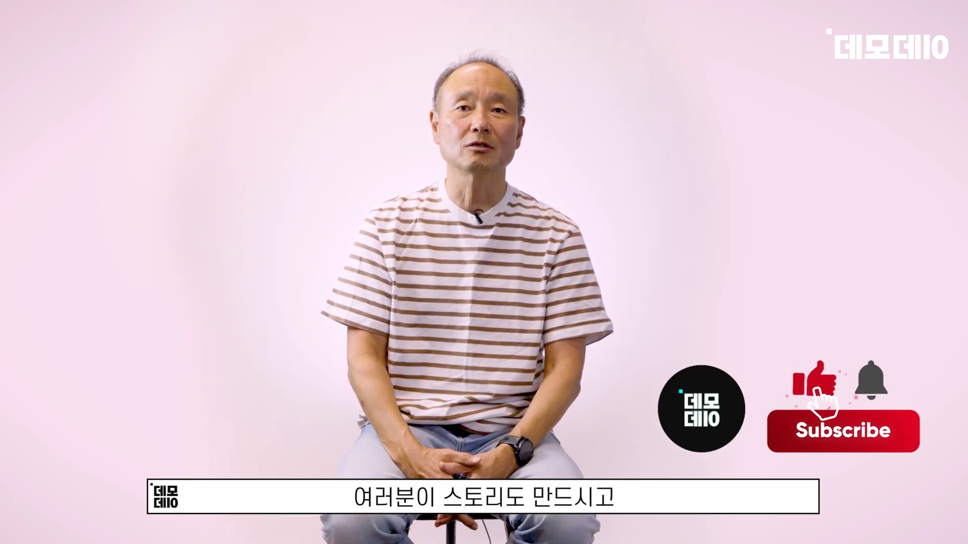 줄무늬 티셔츠를 입은 중년 남성이 밝은 배경 앞에서 앉아 이야기하고 있는 모습