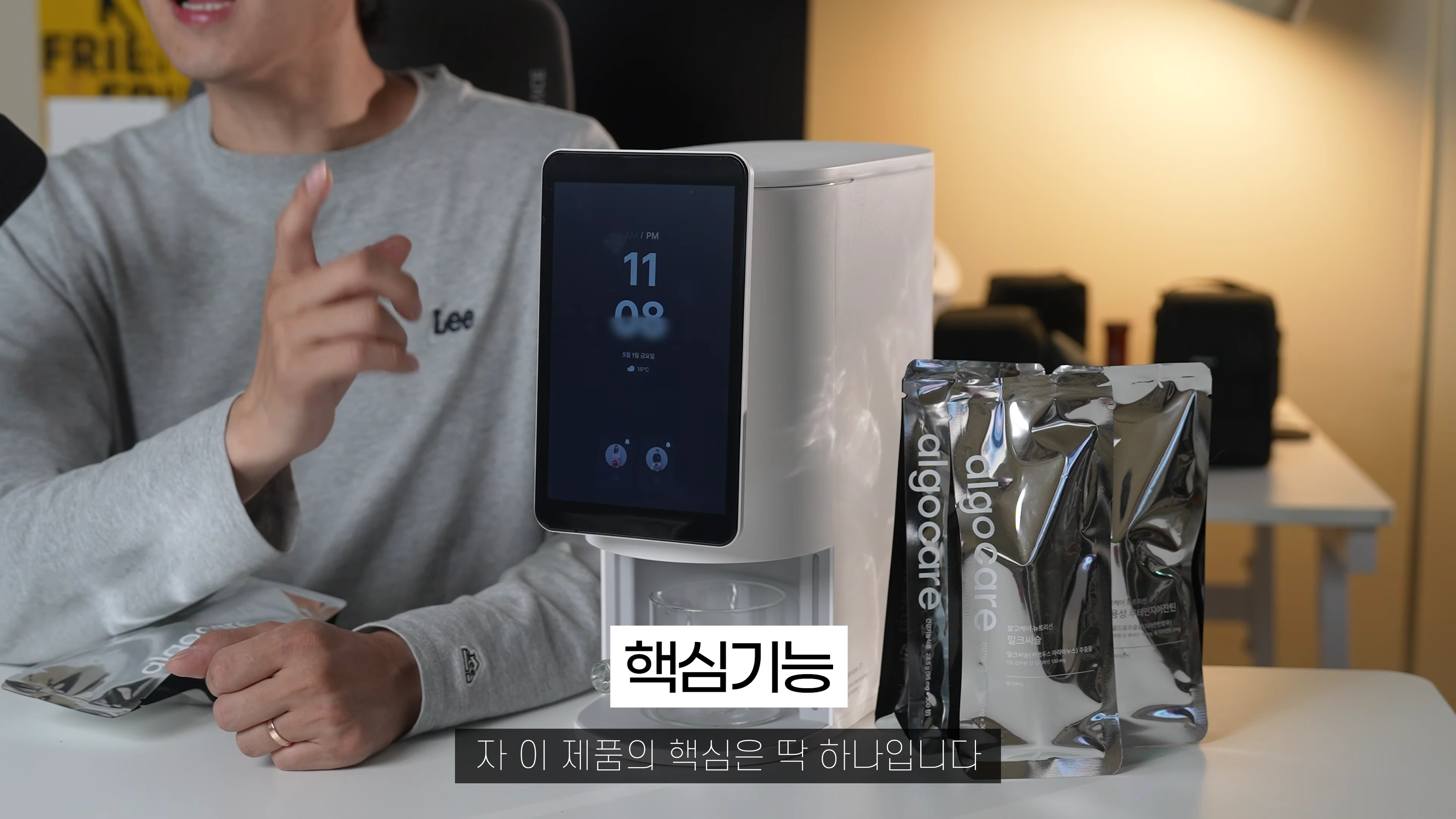 스튜디오 책상 위에 놓인 흰색 AI 영양제 디스펜서와 옆에 놓인 영양제 파우치들