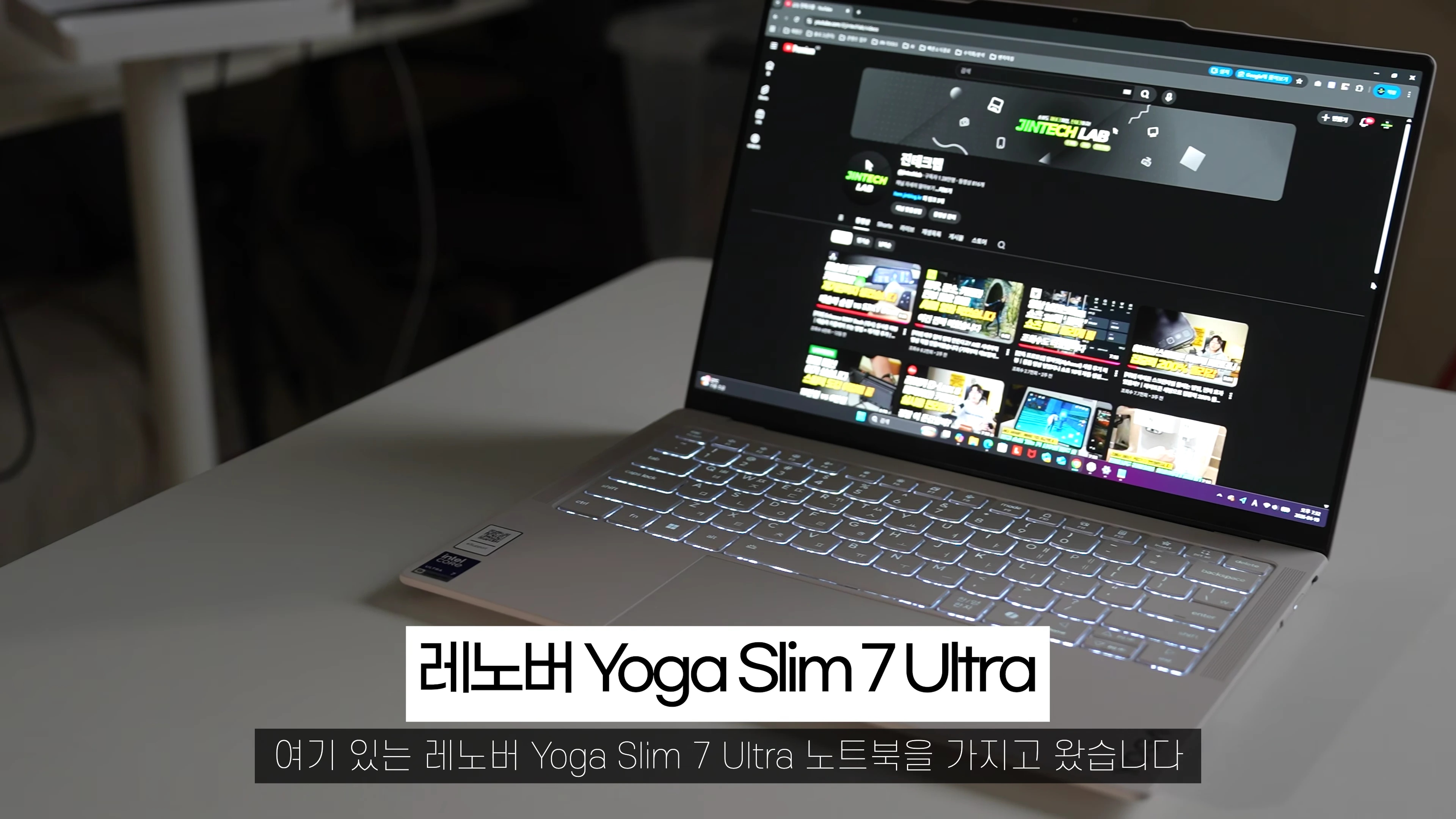 밝은 조명 아래 책상 위에 놓인 레노버 요가 슬림 7 울트라 노트북 화면에 유튜브 채널이 띄워져 있다.