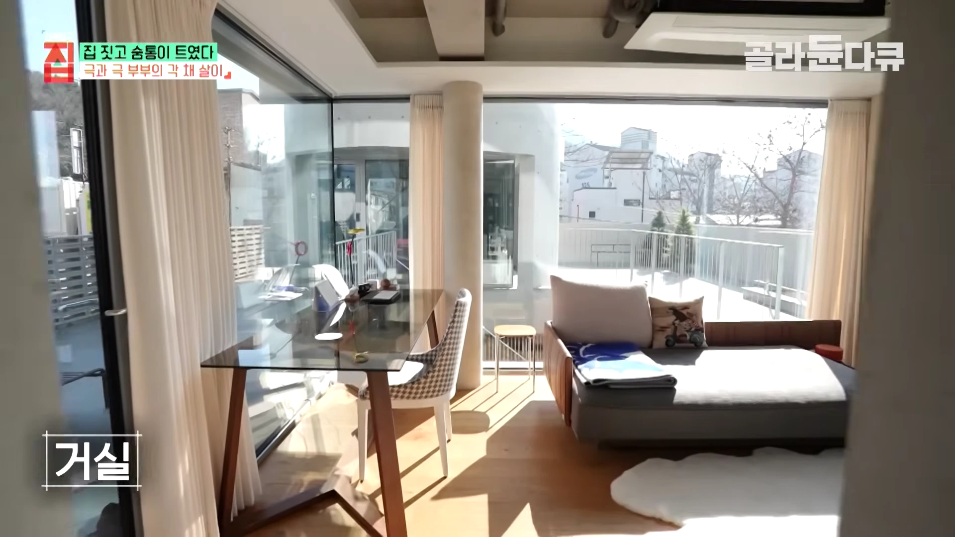 통유리로 둘러싸여 햇살이 가득 들어오는 현대적인 거실 내부 모습