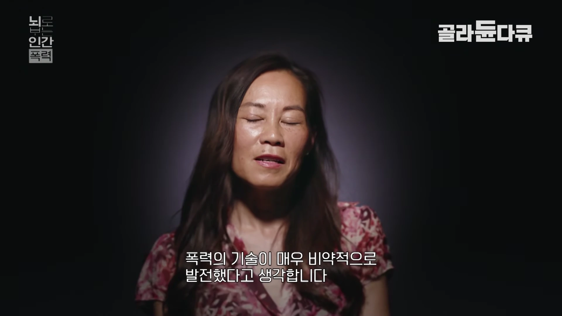 어두운 배경 앞에서 인터뷰 중인 한 여성의 모습이 담긴 영상 화면