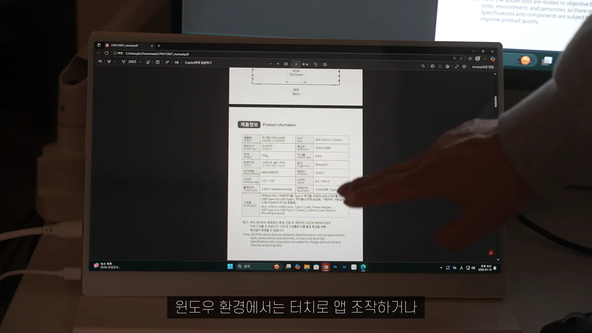 포터블 모니터 화면에 제품 사양표가 띄워져 있고, 손가락으로 화면을 가리키는 모습