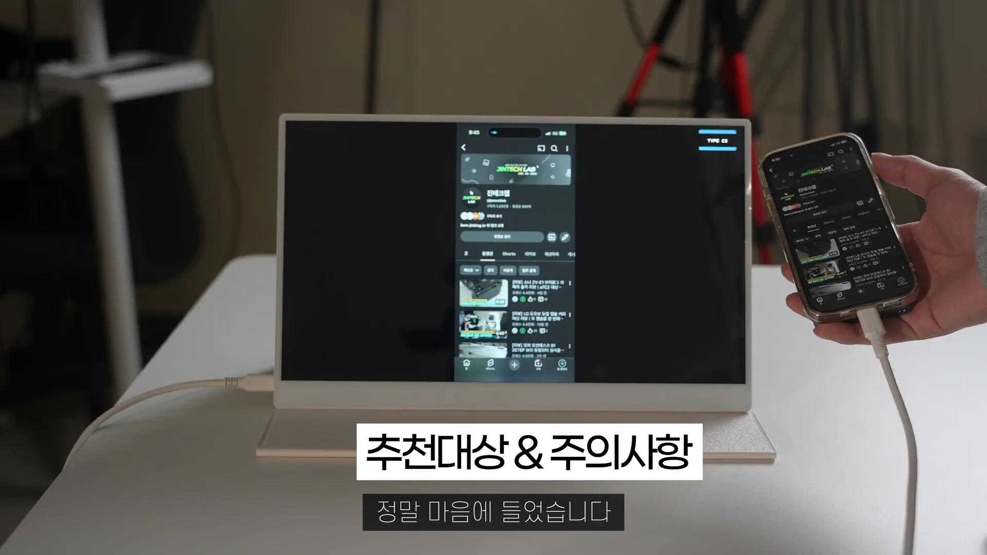 스마트폰과 케이블로 연결된 휴대용 모니터 화면에 유튜브 채널이 출력되고 있는 모습
