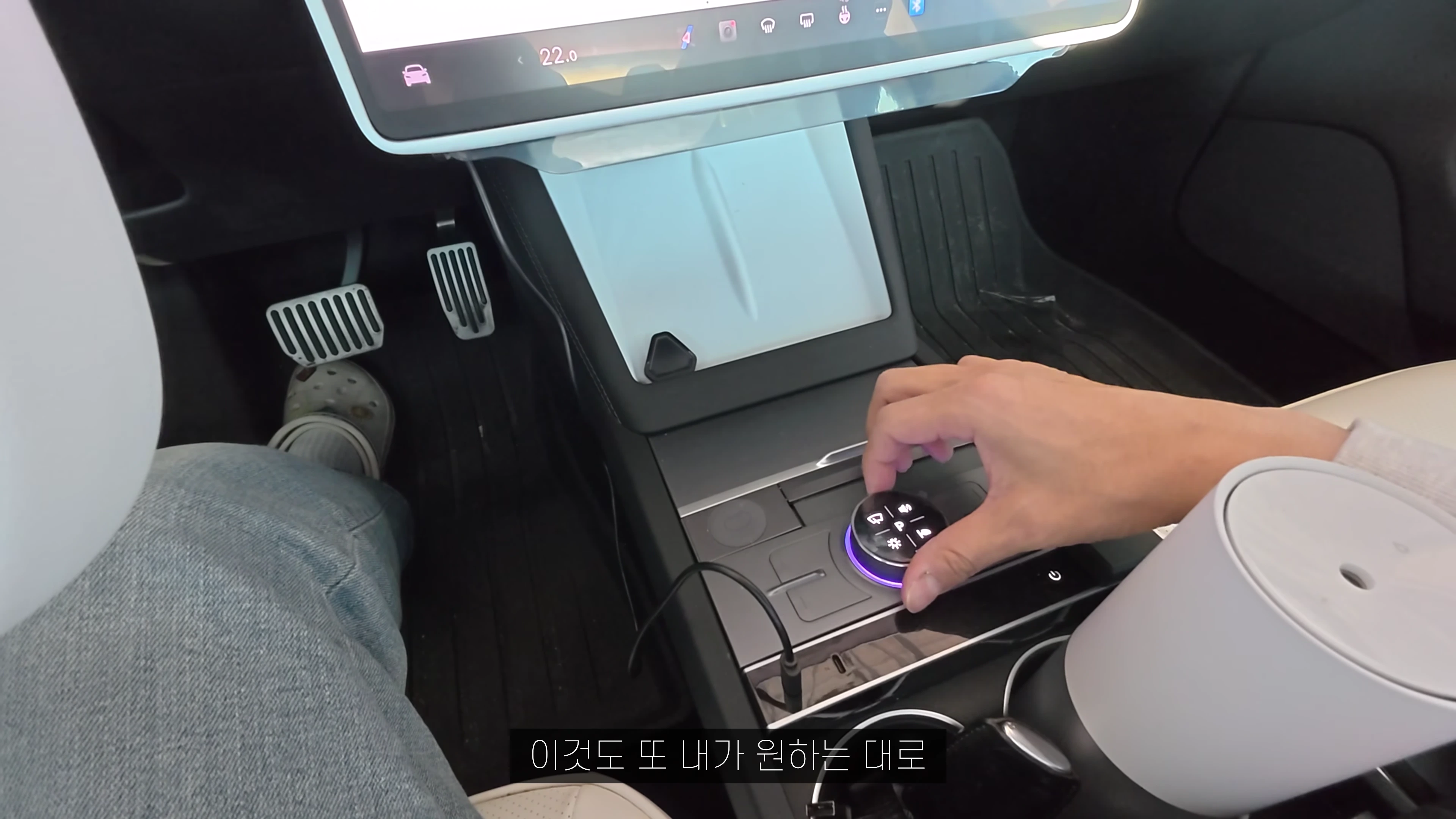 테슬라 차량 센터 콘솔에 설치된 원형 노브를 손으로 조작하는 모습