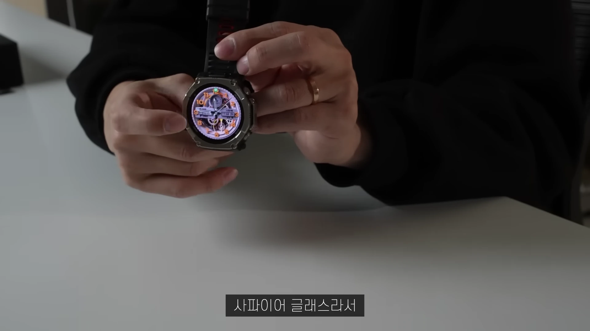 한 사람이 손으로 티타늄 소재의 스마트워치를 들고 화면을 보여주고 있는 모습