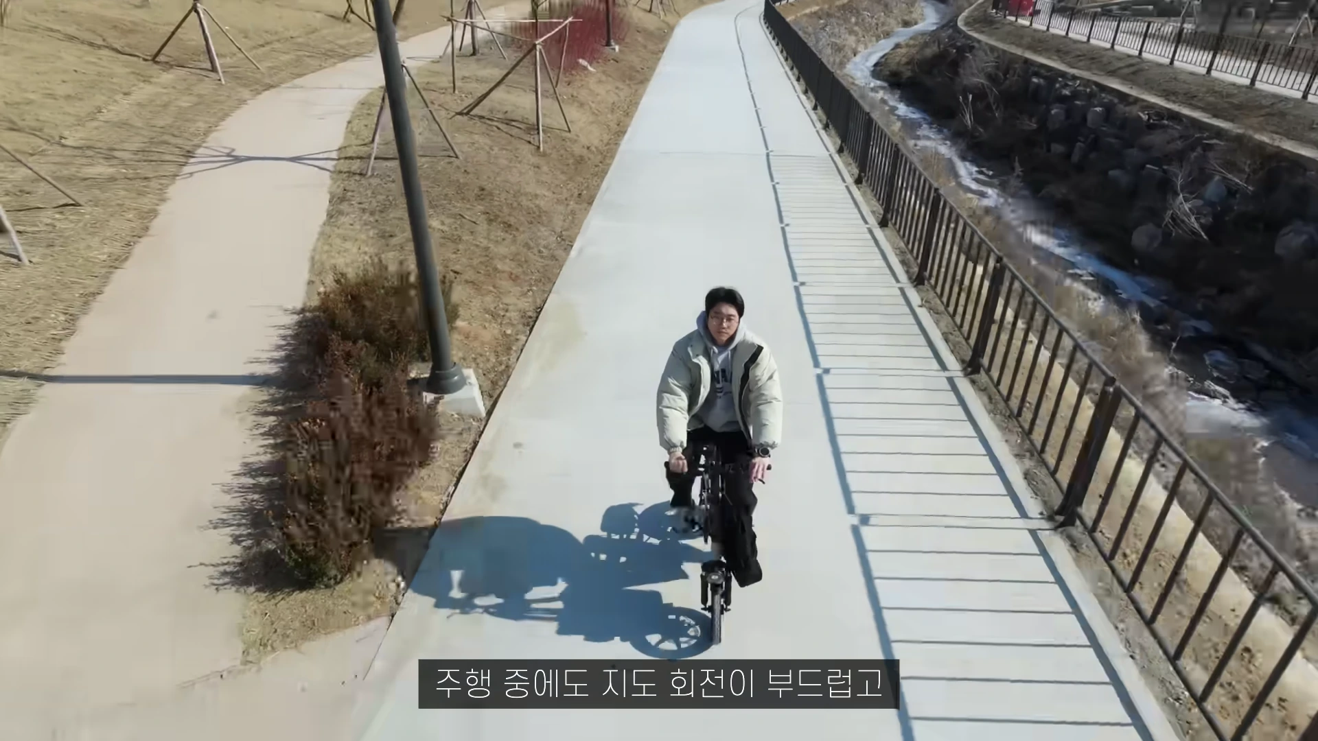 야외 산책로에서 전기자전거를 타는 남성을 위에서 내려다본 모습