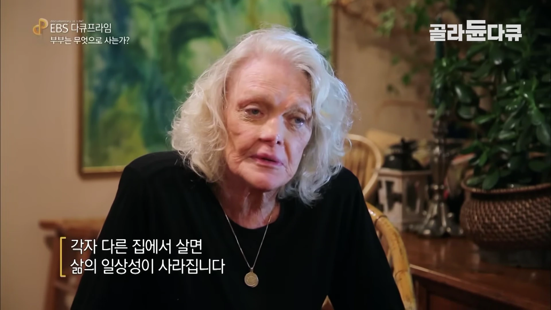 백발의 중년 여성이 실내에서 인터뷰를 하고 있는 모습
