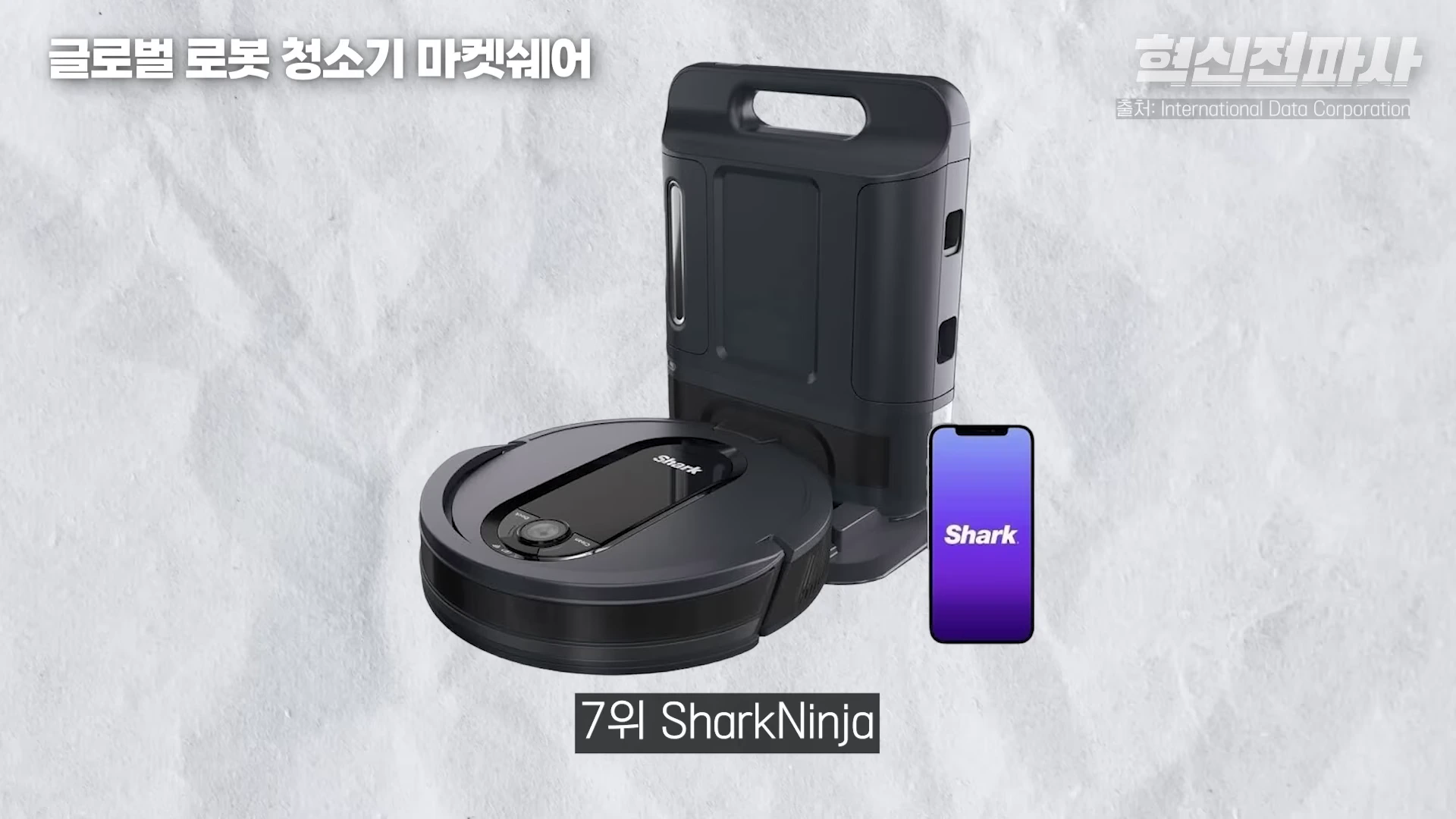 검은색 로봇청소기와 충전 스테이션, 그리고 브랜드 로고가 띄워진 스마트폰이 나란히 놓여 있는 모습