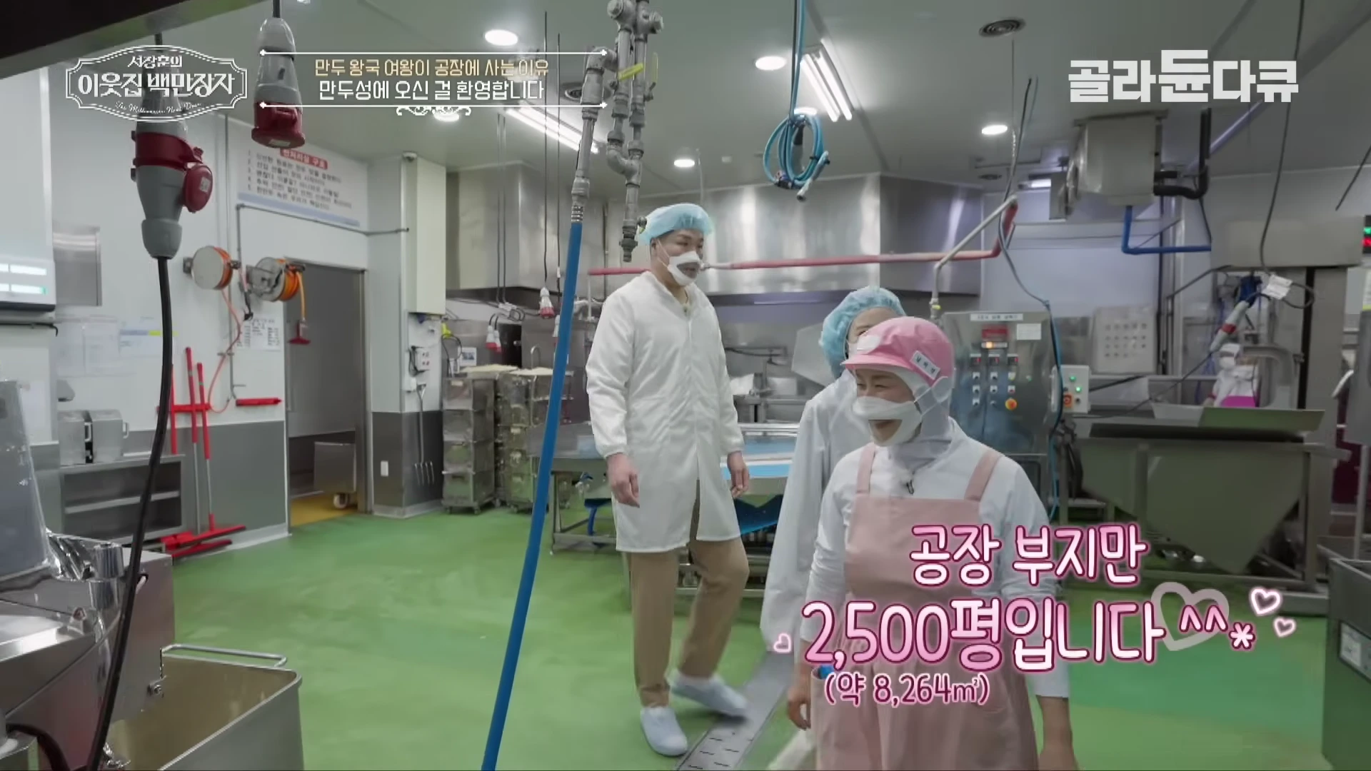 위생복을 입은 사람들이 만두 공장 내부를 둘러보고 있는 모습