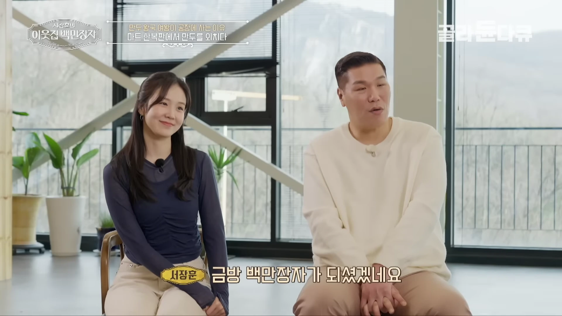 밝은 실내에서 남녀 두 사람이 대화를 나누고 있는 인터뷰 장면