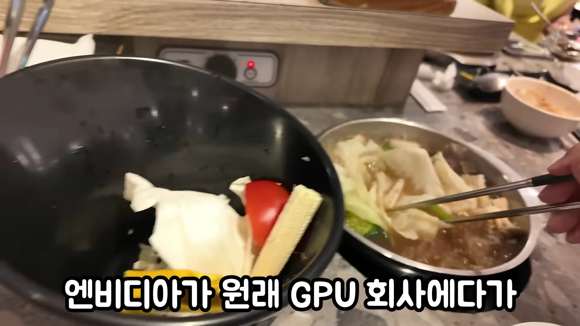 식당 테이블 위에서 젓가락으로 샤브샤브 재료를 집고 있는 모습과 화면 하단의 자막