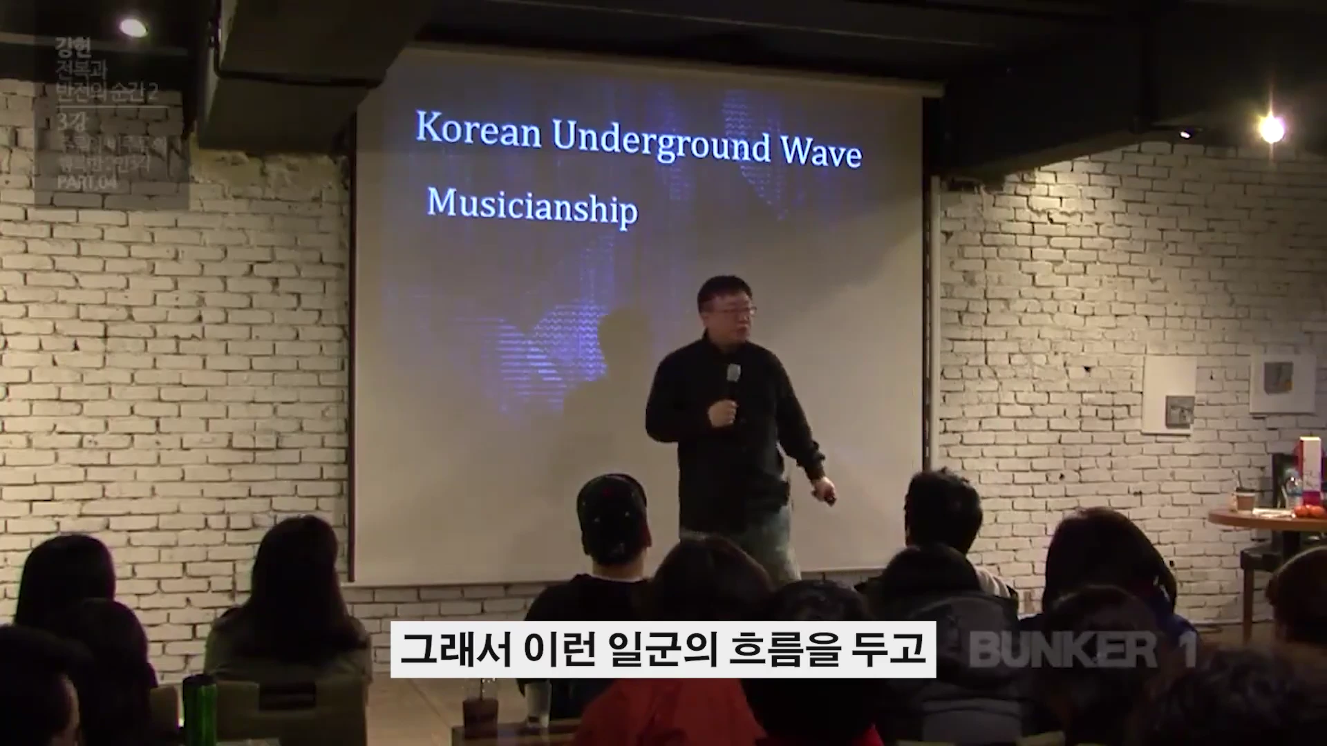 강연자가 스크린 앞에 서서 청중을 향해 이야기하고 있으며, 스크린에는 'Korean Underground Wave Musicianship'이라는 문구가 적혀 있습니다.