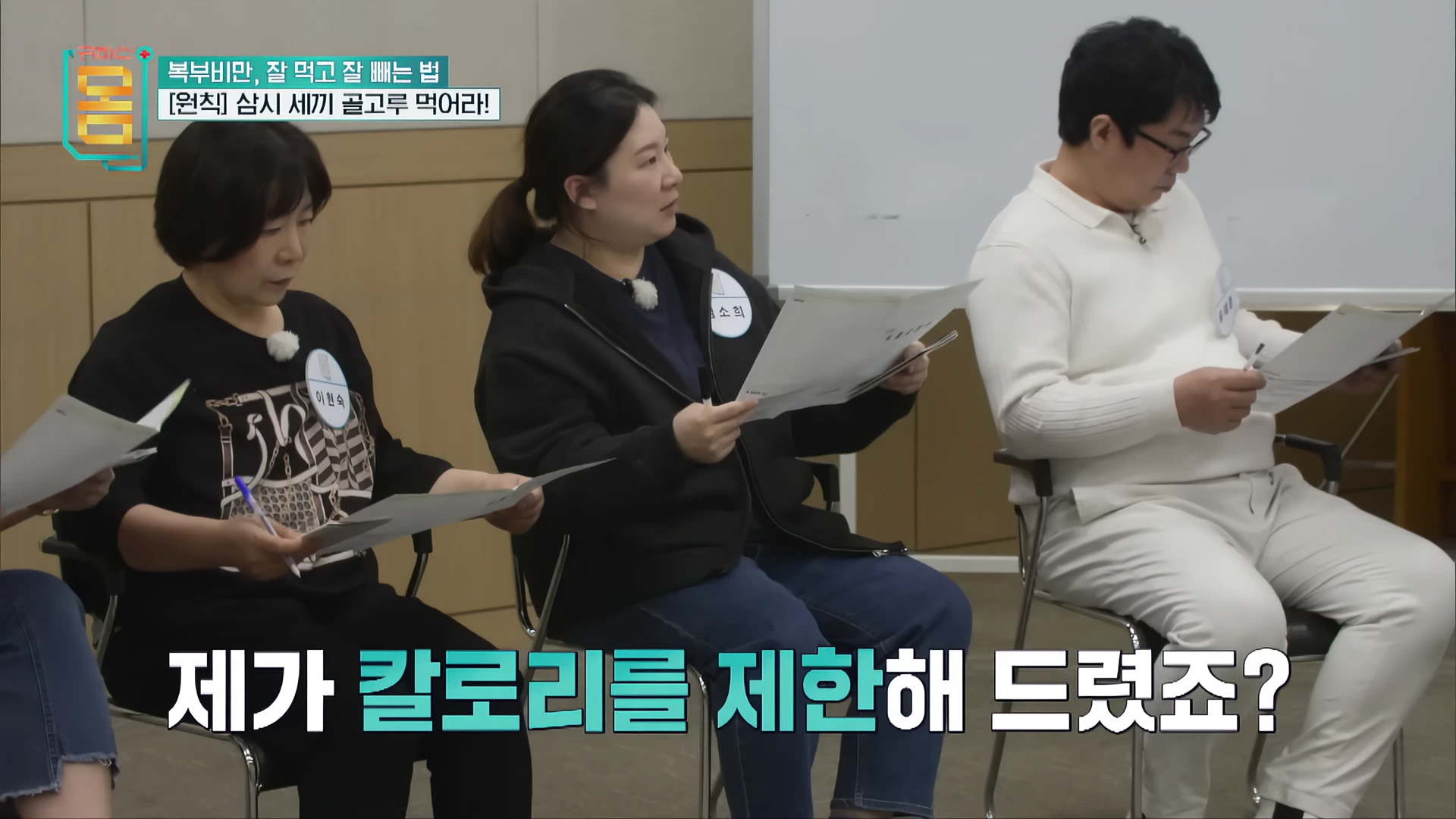 강의실에 앉아 자료를 보며 전문가의 설명을 듣는 참가자들