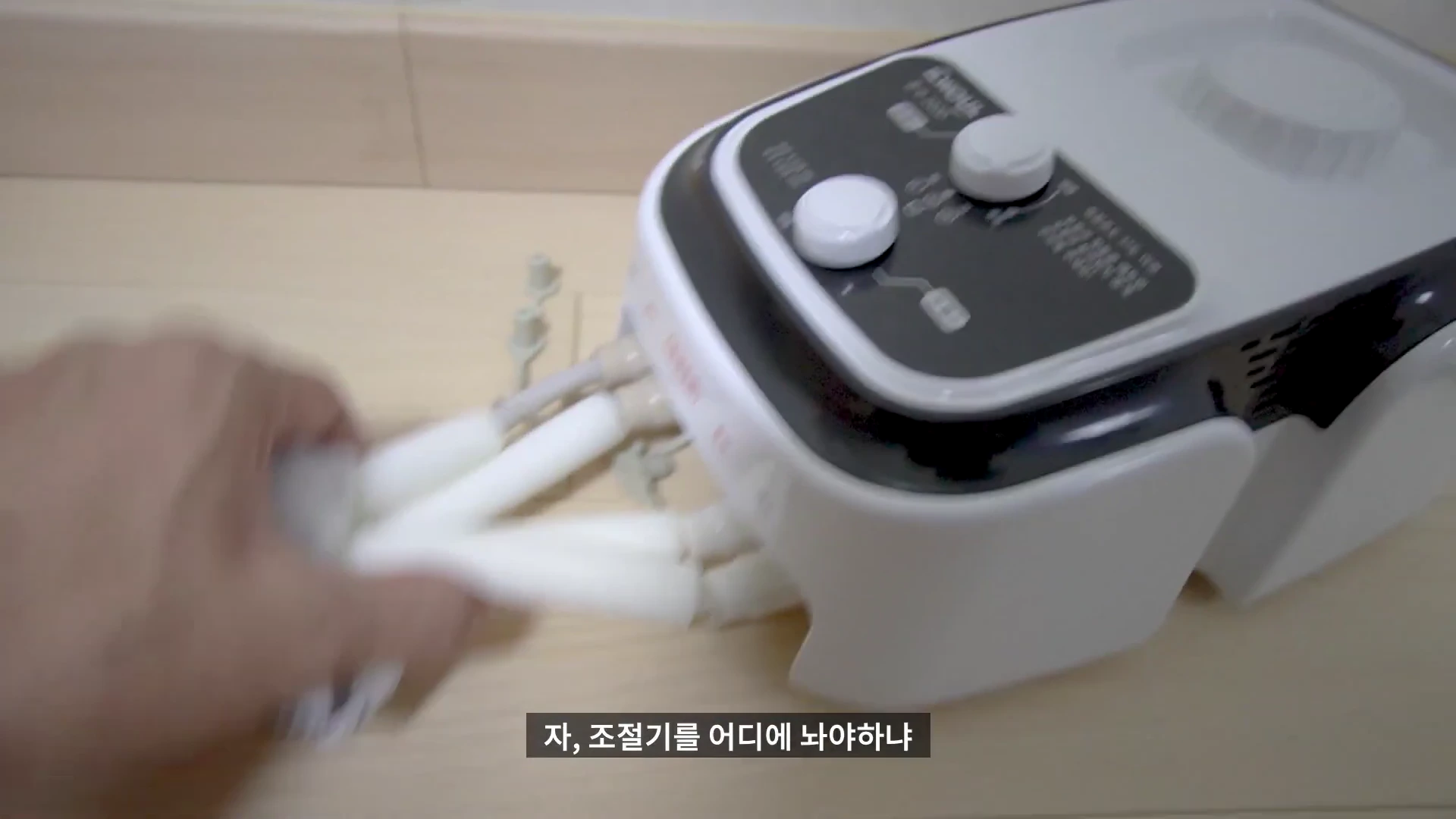 온수매트 조절기에 연결된 호스를 손으로 잡고 있는 모습