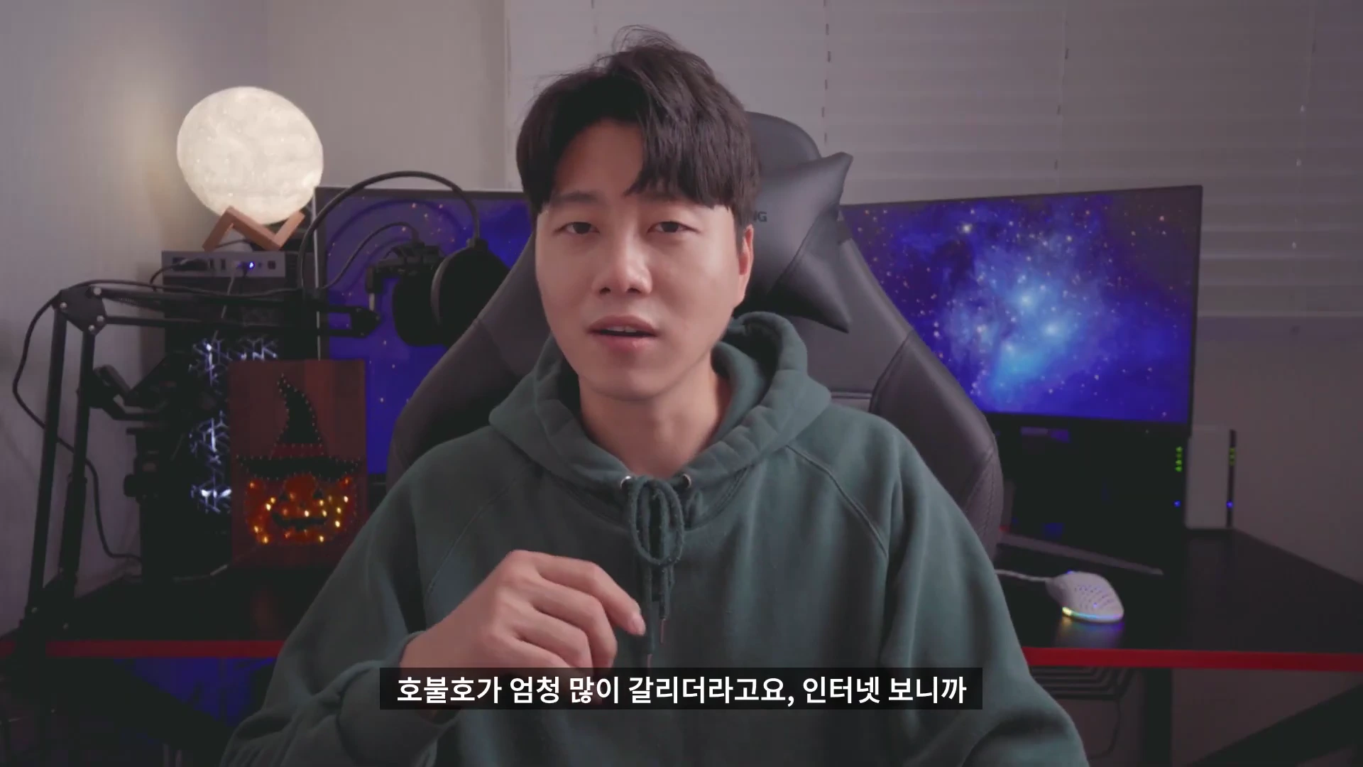 게이밍 의자에 앉아 카메라를 응시하며 이야기하는 남성