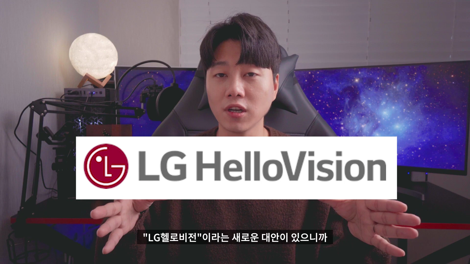 카메라를 응시하며 설명하는 남성과 화면 중앙에 배치된 LG헬로비전 로고