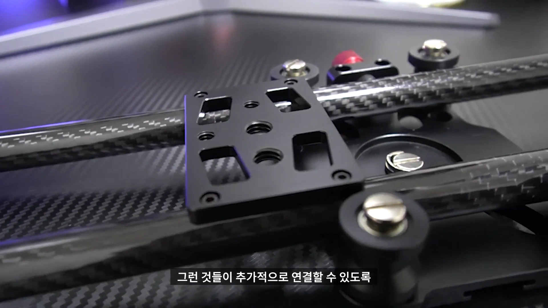 카본 소재의 레일과 카메라를 고정할 수 있는 마운트 플레이트가 결합된 슬라이더 장비의 근접 촬영 화면