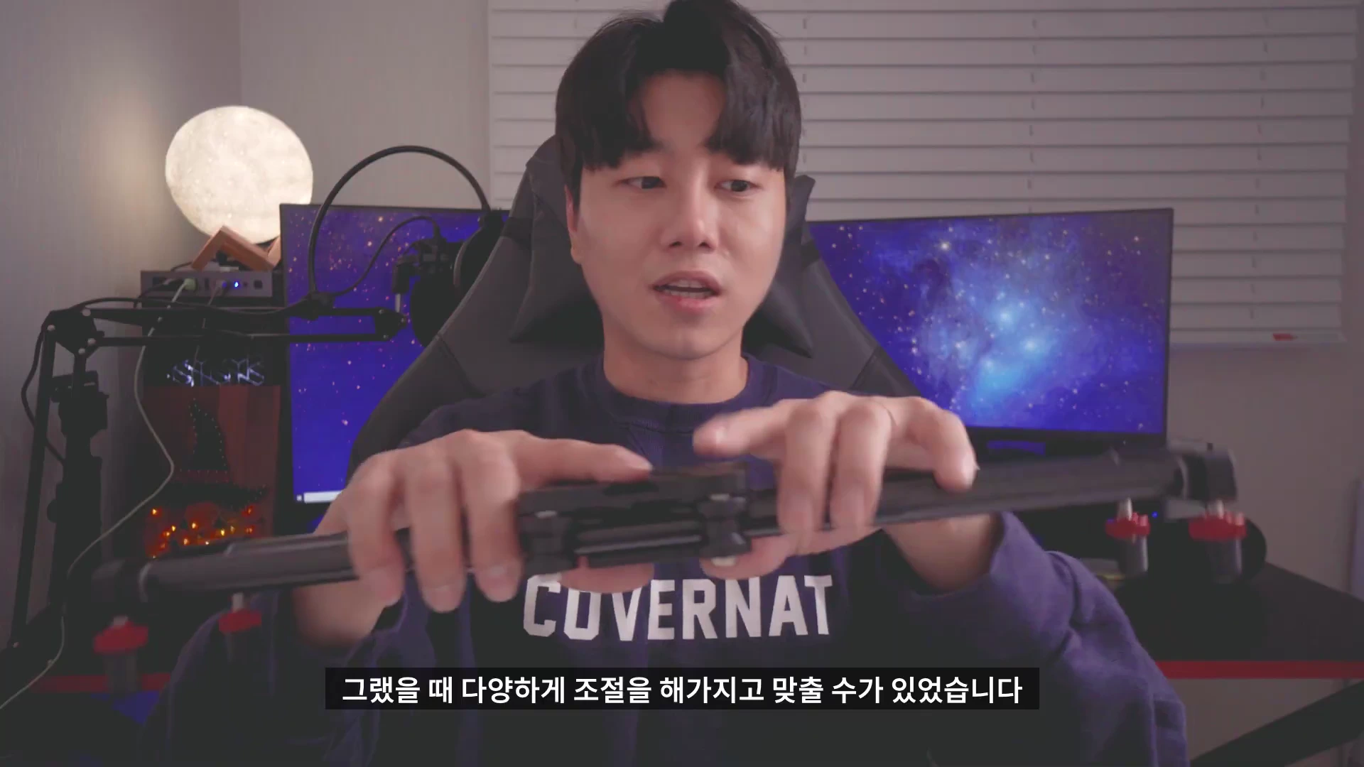 실내에서 남성이 손으로 수동 슬라이더의 레일을 잡고 조작법을 설명하는 모습