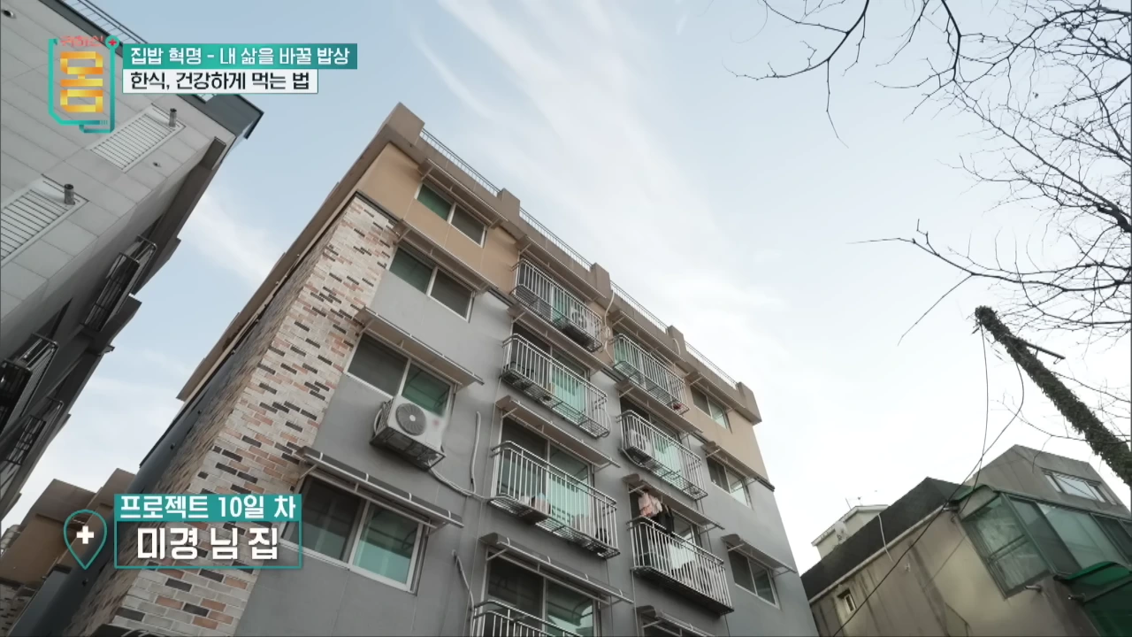 맑은 하늘 아래 베란다 창문이 줄지어 있는 다세대 주택 건물의 외관 모습