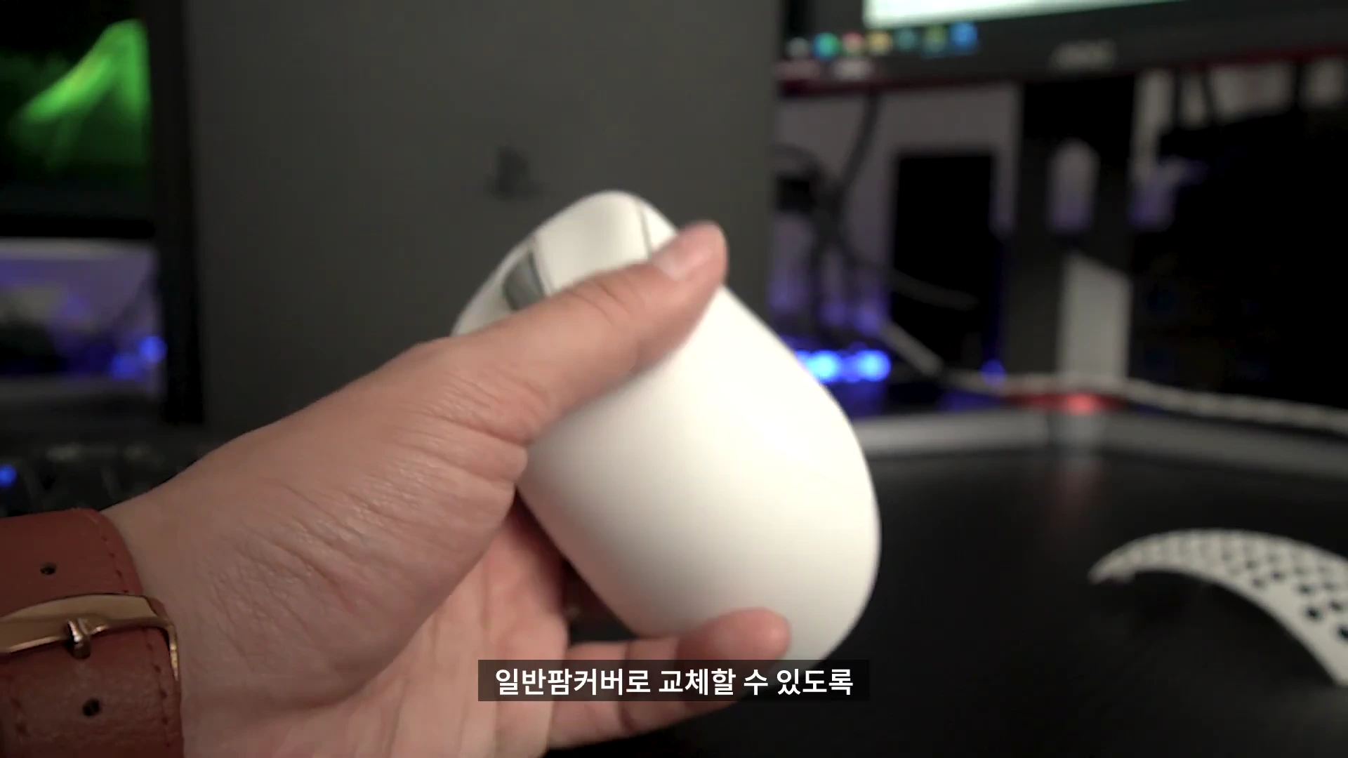손에 들린 흰색 무선 게이밍 마우스와 주변의 마우스 커버