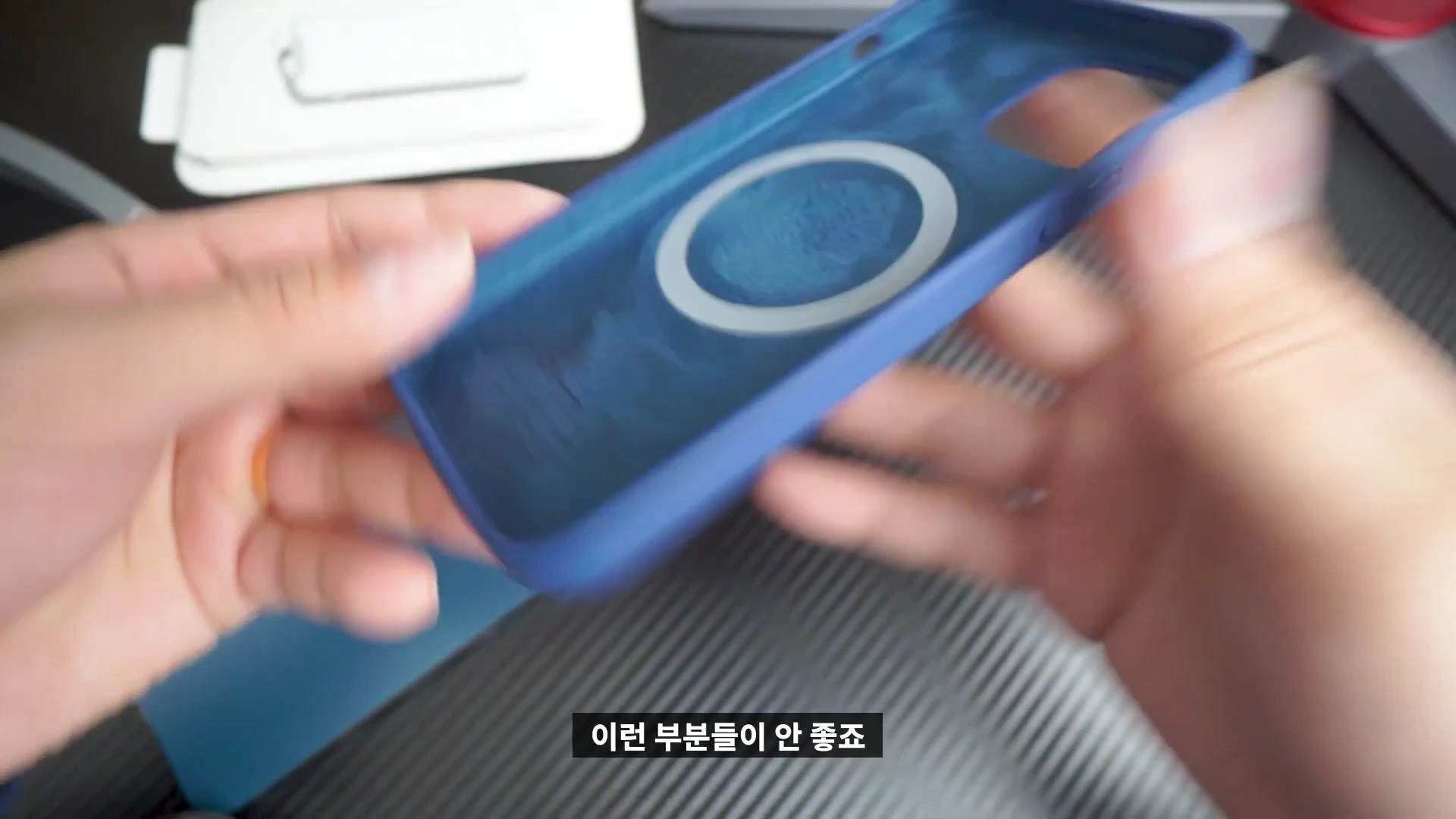 손으로 파란색 맥세이프 호환 아이폰 케이스 안쪽의 스웨이드 재질과 자석 부분을 보여주는 모습