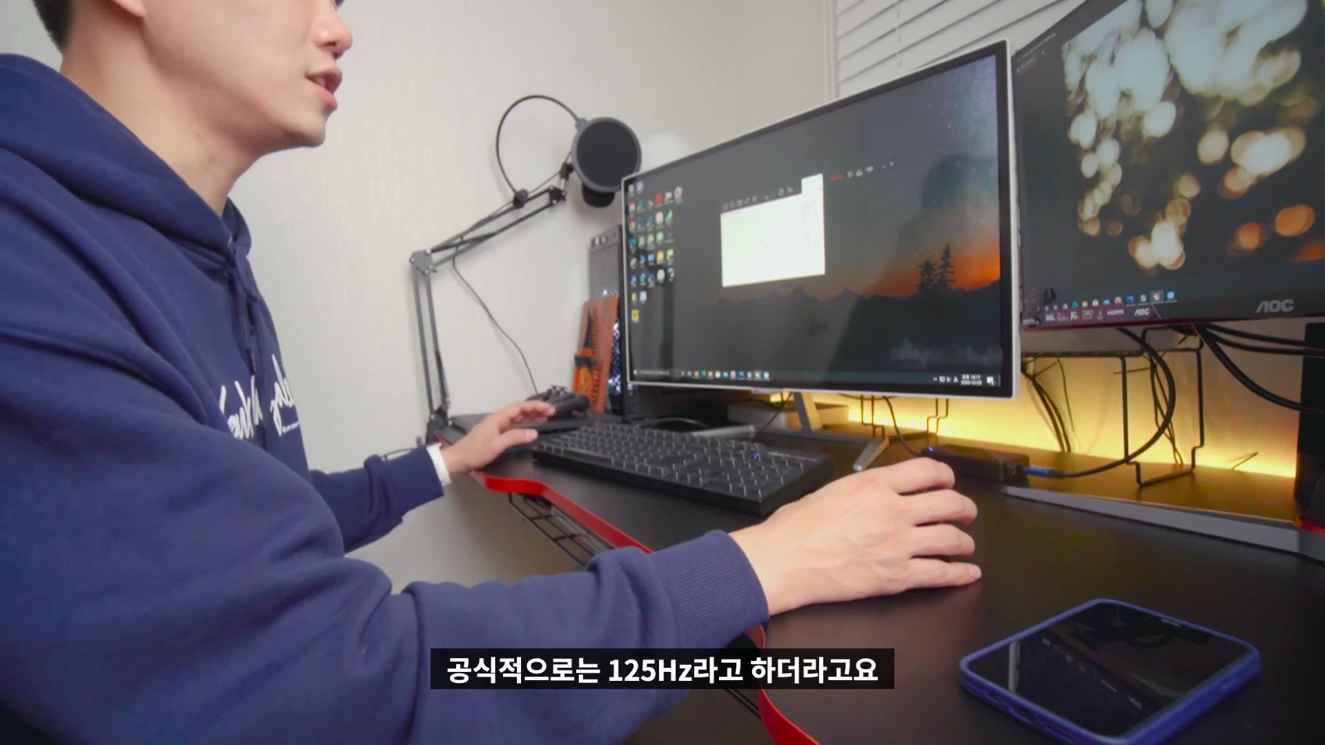책상 앞에 앉아 컴퓨터를 사용하는 남성의 옆모습과 모니터 화면