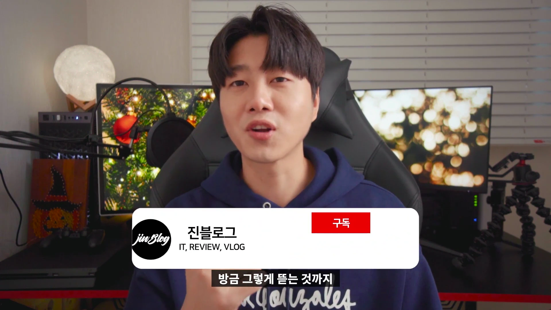 IT 리뷰어 남성이 책상 앞에 앉아 카메라를 보며 이야기하고 있는 모습
