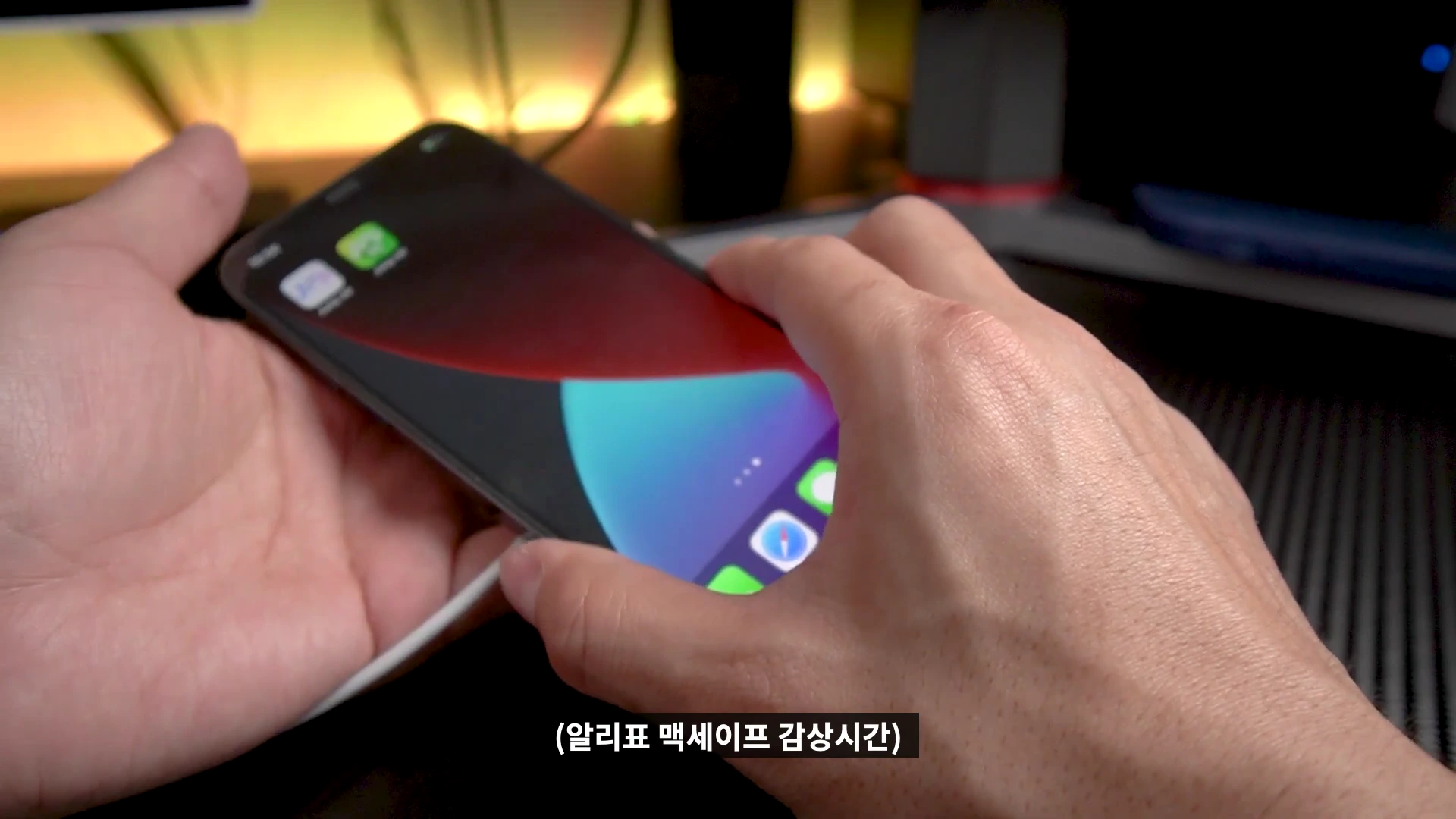 스마트폰 뒷면에 맥세이프 충전기를 부착하는 손의 모습