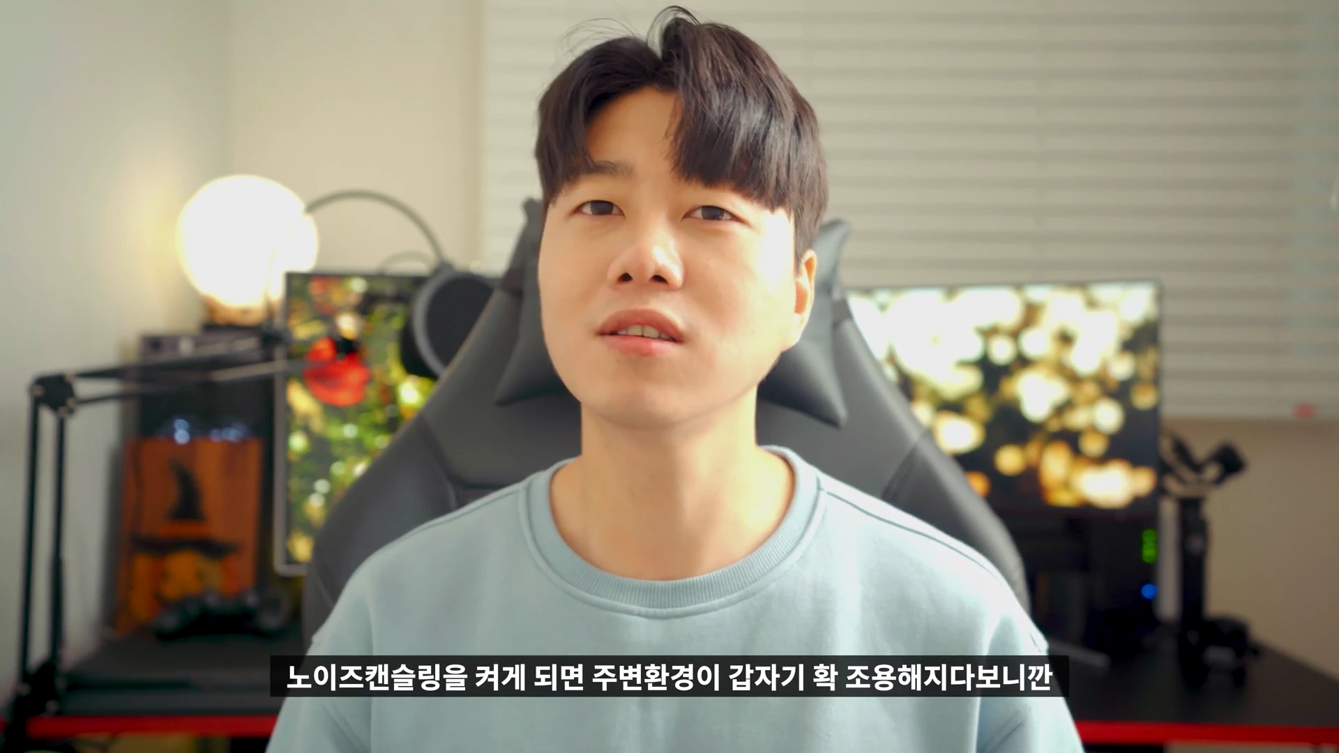 밝은 실내에서 헤드셋을 착용하지 않은 남성이 카메라를 정면으로 응시하며 이야기하고 있다.