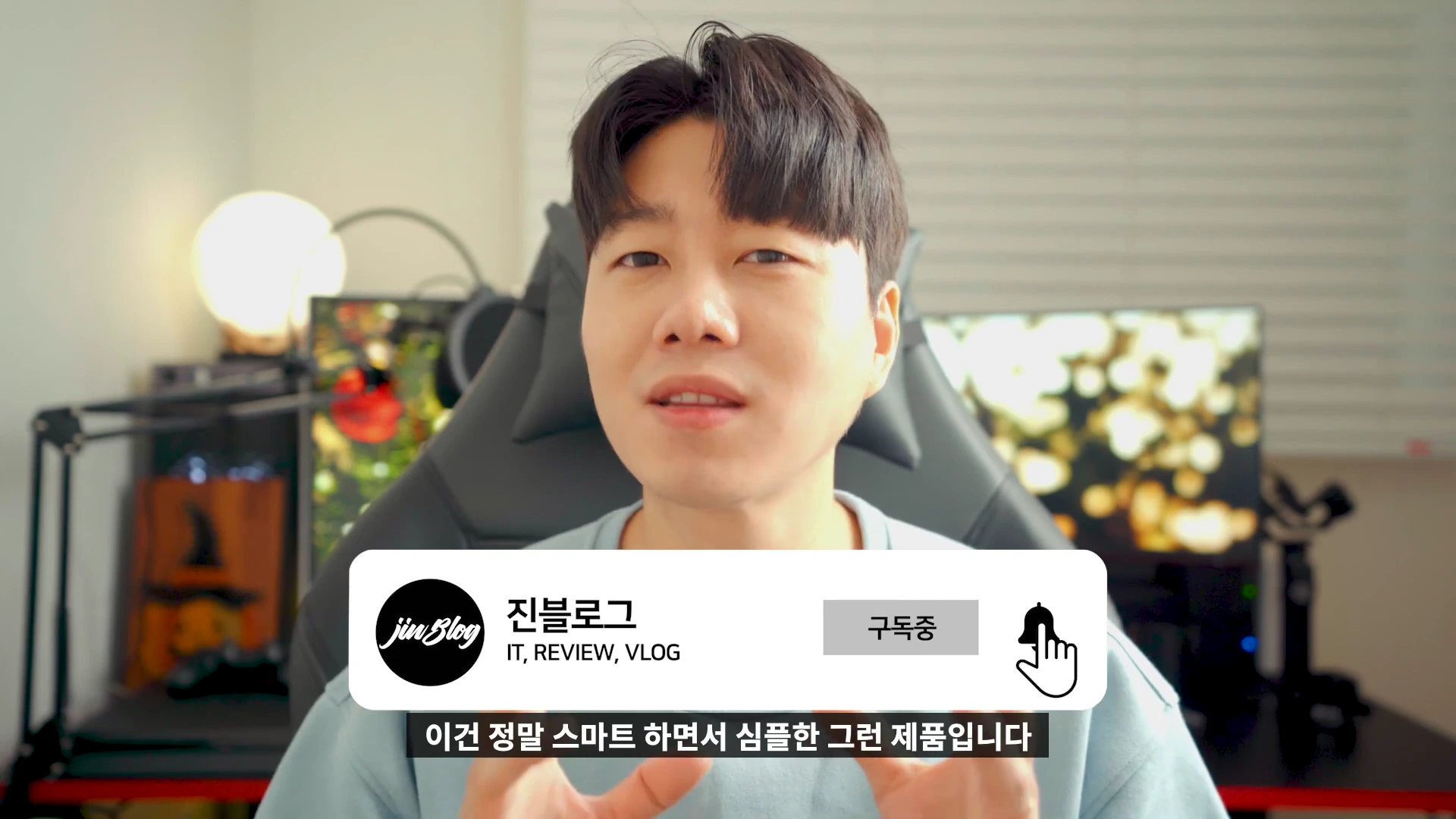 실내에서 카메라를 응시하며 이야기하는 남성 뒤로 게이밍 의자와 모니터가 보이고, 화면 하단에는 채널 로고와 구독 버튼이 포함된 자막이 떠 있다.
