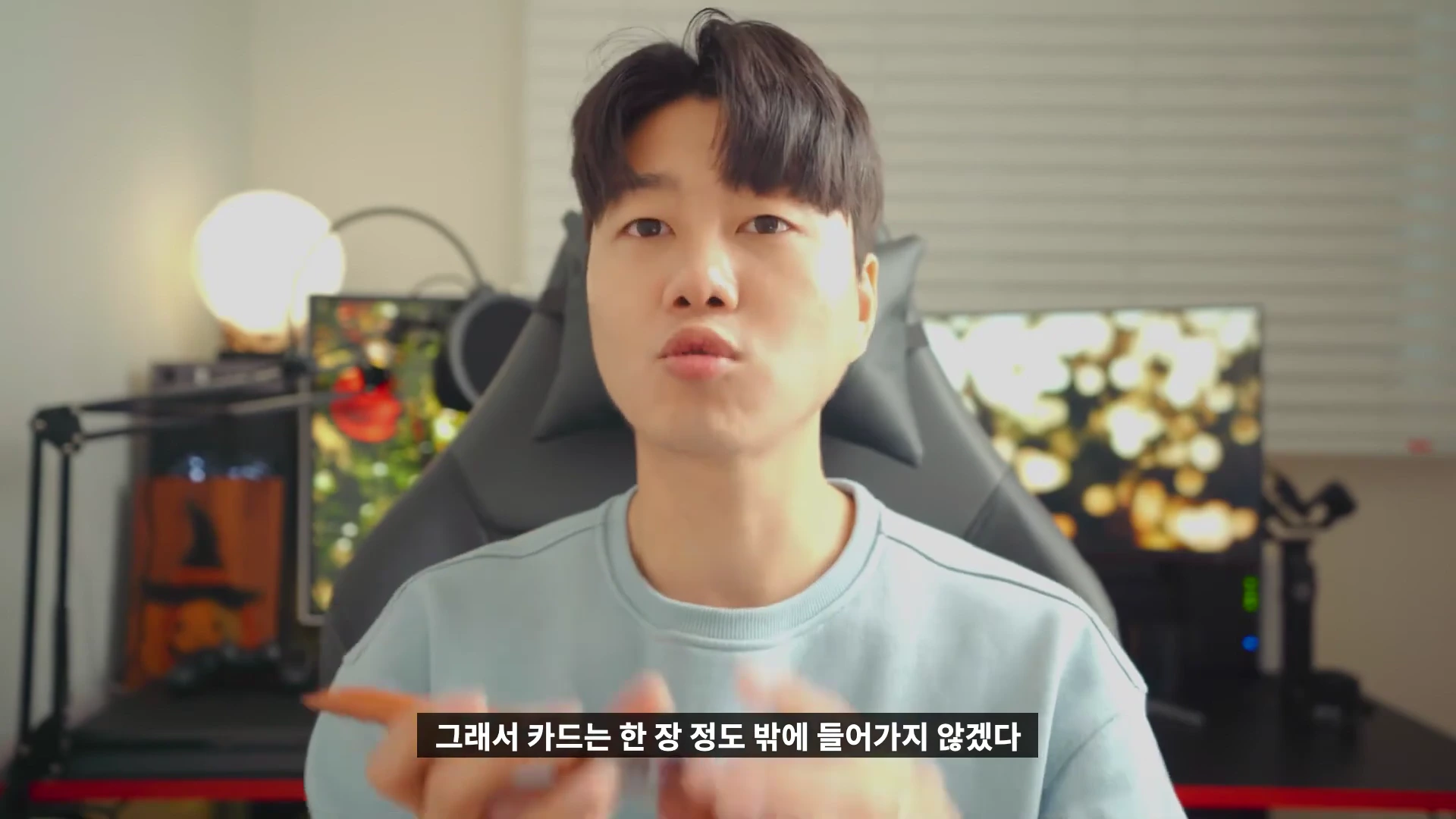 밝은색 맨투맨을 입은 남성이 카메라를 보며 슬리브의 카드 수납 기능에 대해 설명하고 있다.