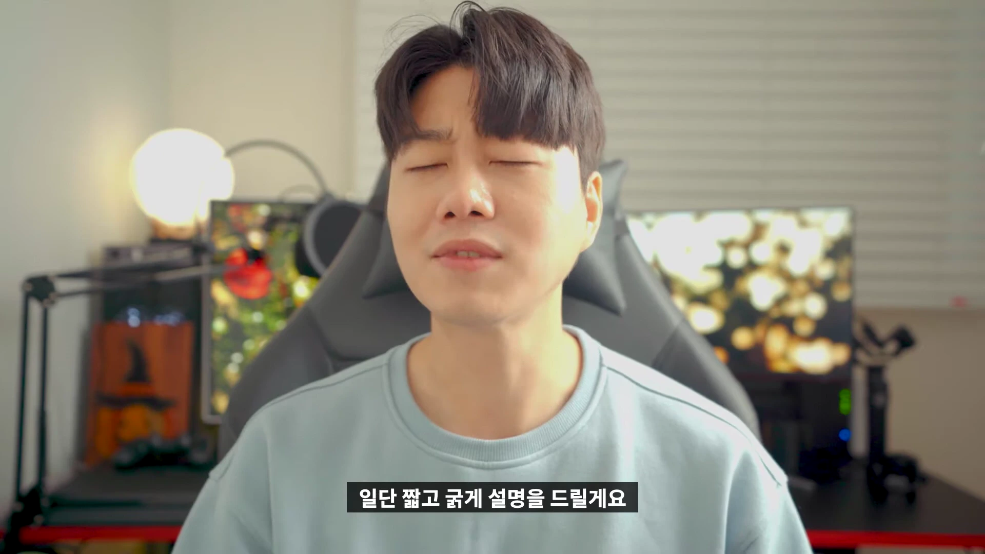 실내 책상 앞에 앉아 눈을 감고 이야기하는 남성