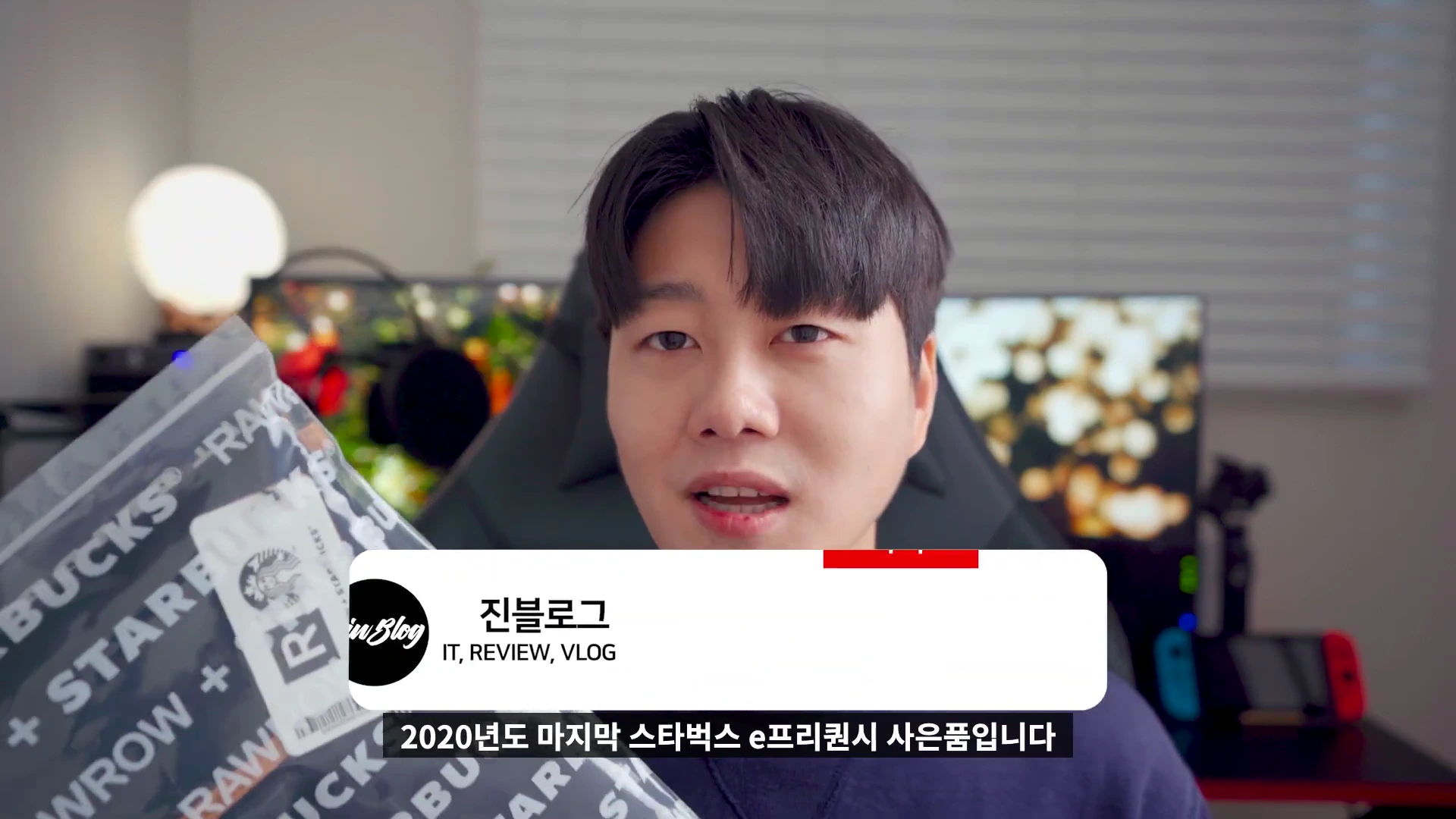 한 남성이 스타벅스 로고가 새겨진 포장지를 들고 카메라를 보며 이야기하고 있다.