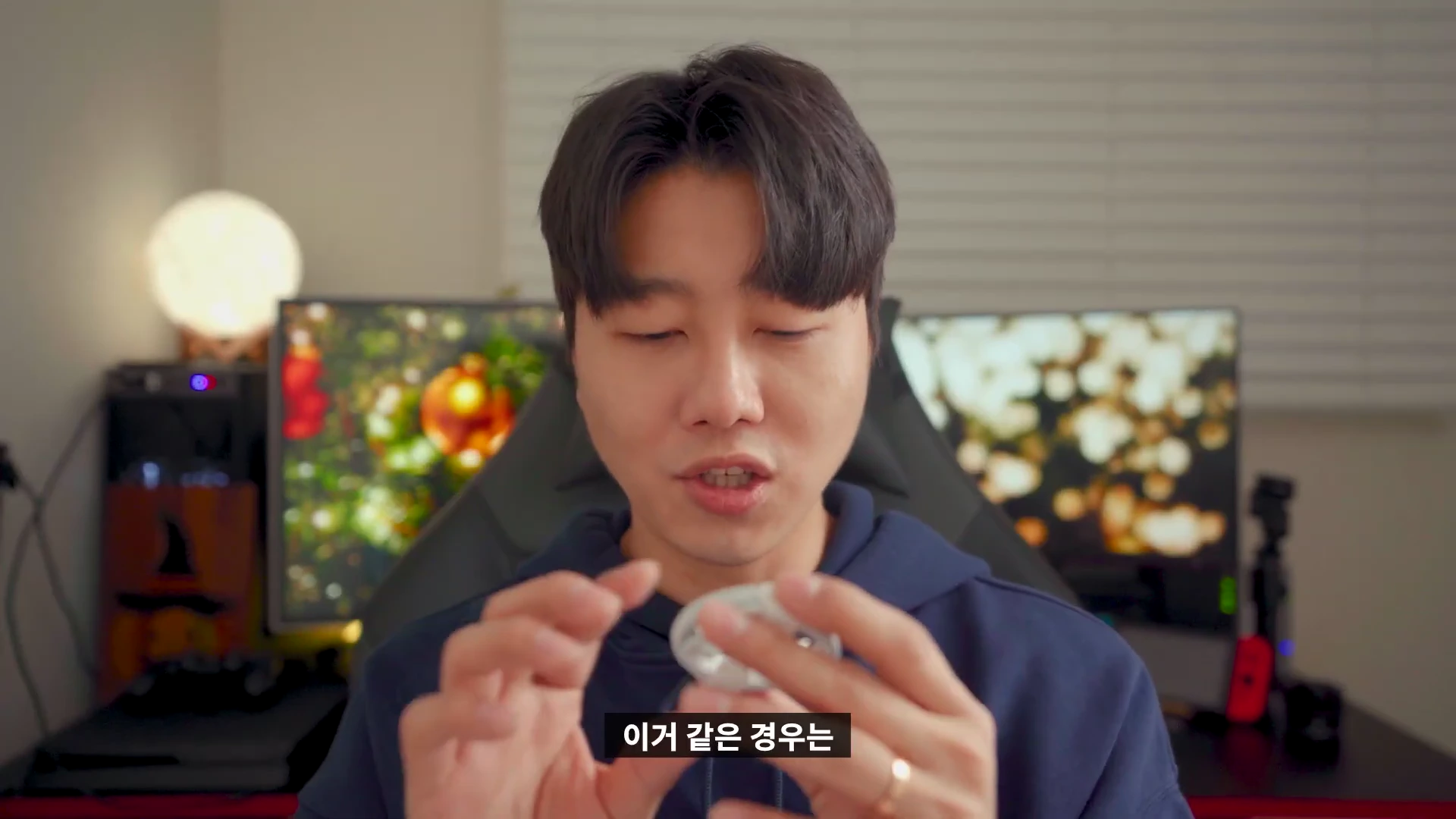 실내에서 남성이 손에 든 작은 원형의 무선 충전기 부품을 보여주고 있다.