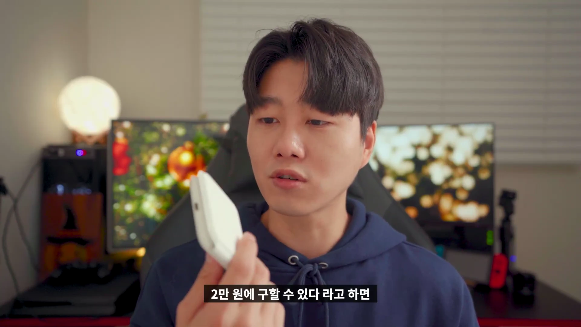 실내에서 남성이 흰색 폴더블 무선 충전기를 손에 들고 살펴보는 모습