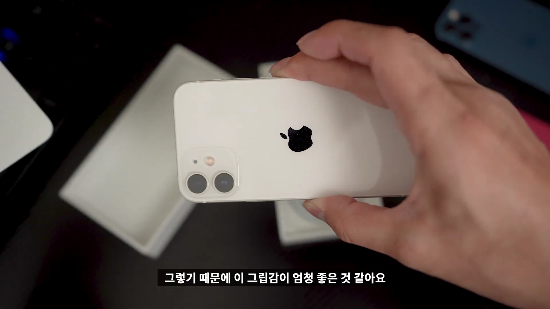 한 손에 쏙 들어오는 흰색 아이폰 12 미니를 손으로 들고 있는 모습