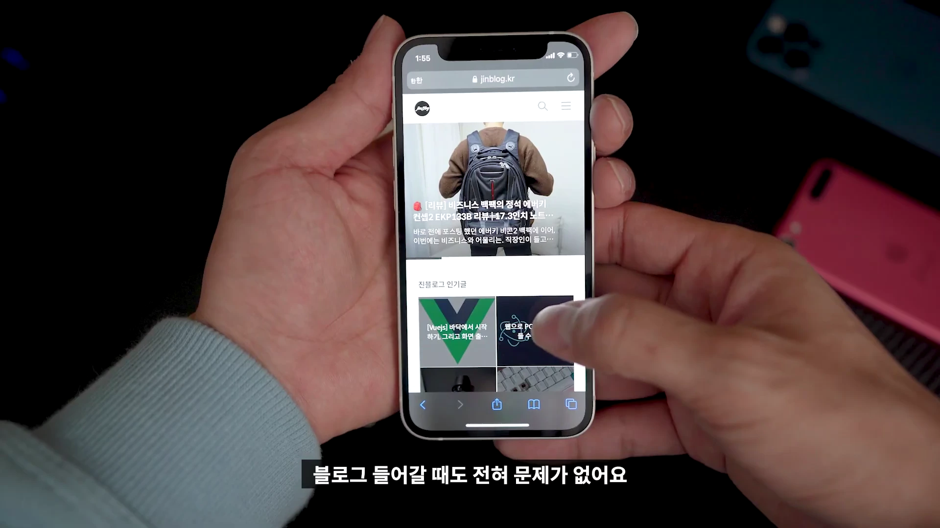 양손으로 아이폰 12 미니를 들고 웹 페이지를 탐색하는 모습