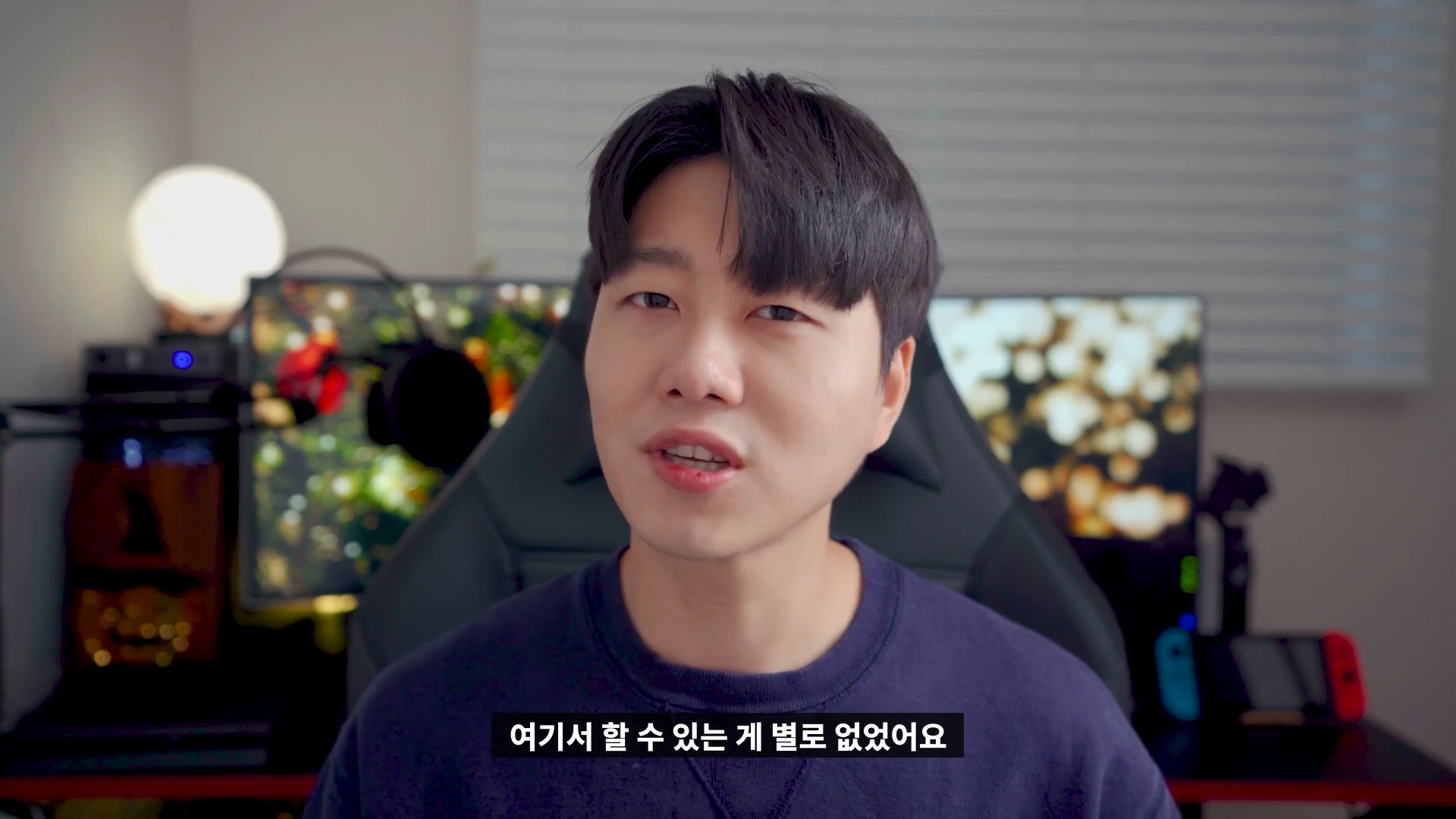 실내에서 카메라를 응시하며 이야기하는 남성, 하단에 자막이 표시된 영상 화면