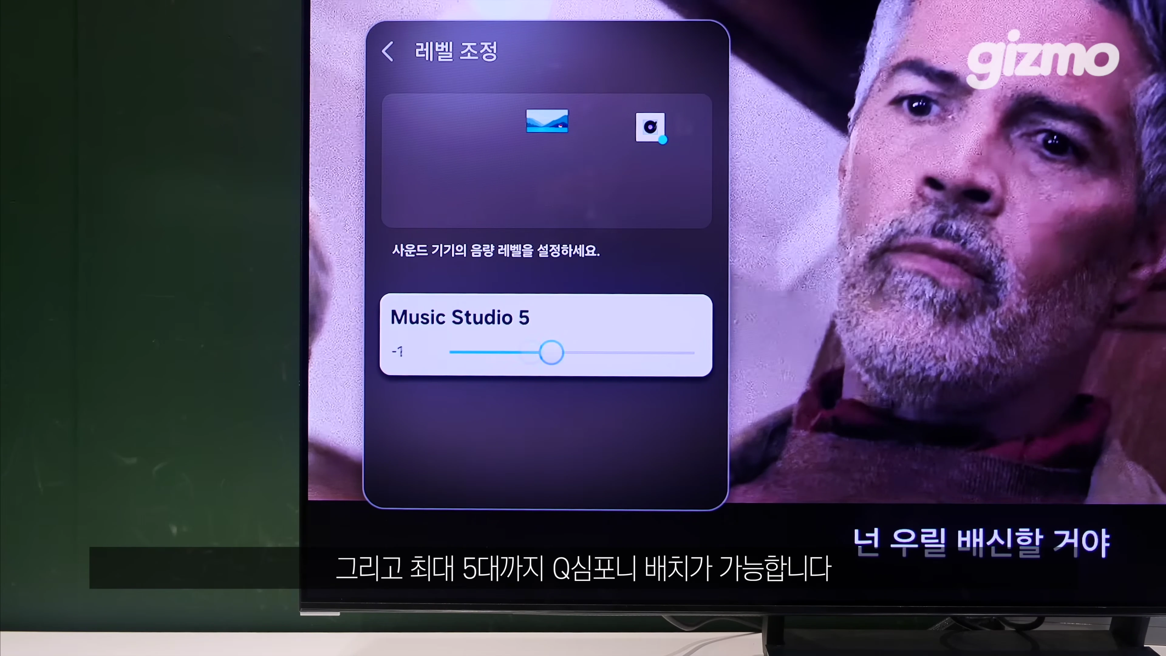 TV 화면에 표시된 사운드 기기 레벨 조정 설정 메뉴와 영화 장면
