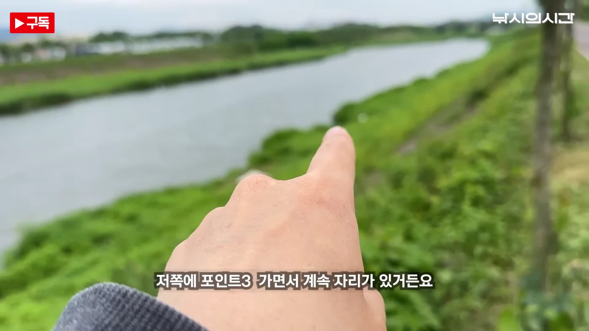 낚시인이 강변의 낚시 포인트를 손가락으로 가리키고 있는 모습
