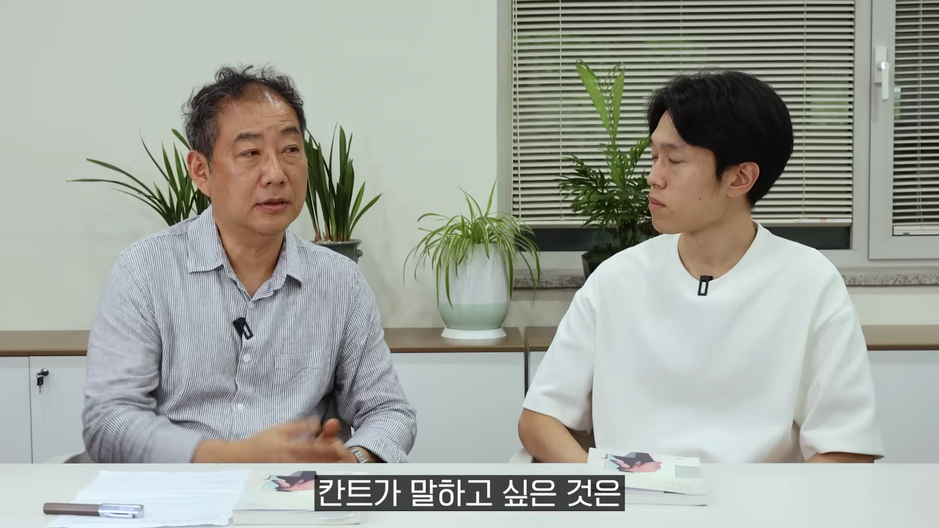 실내에서 두 남성이 대화를 나누고 있는 유튜브 영상 화면